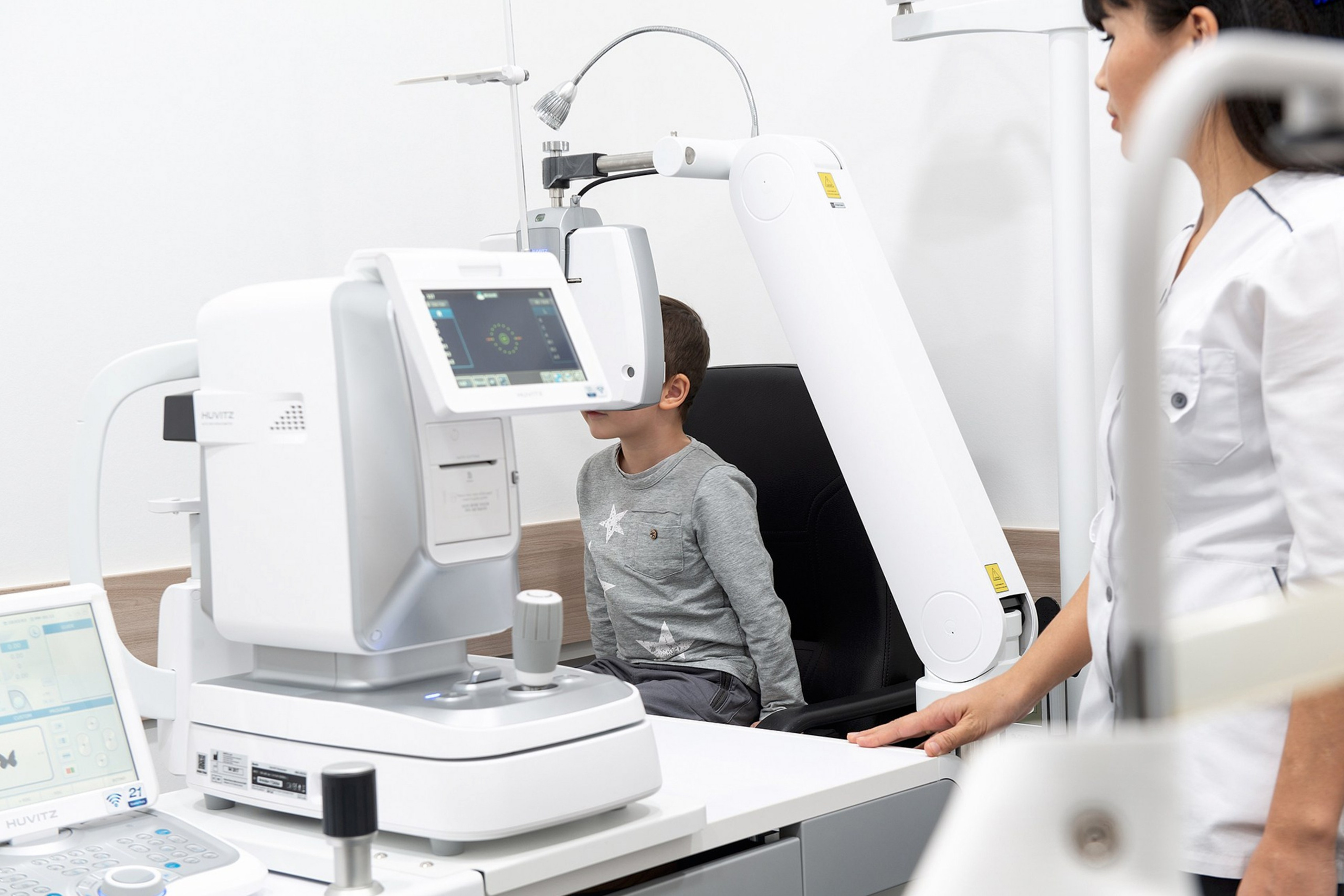 Обследование зрения ребёнка на офтальмологическом оборудовании — пример индустриальной фотосъёмки медицинского учреждения