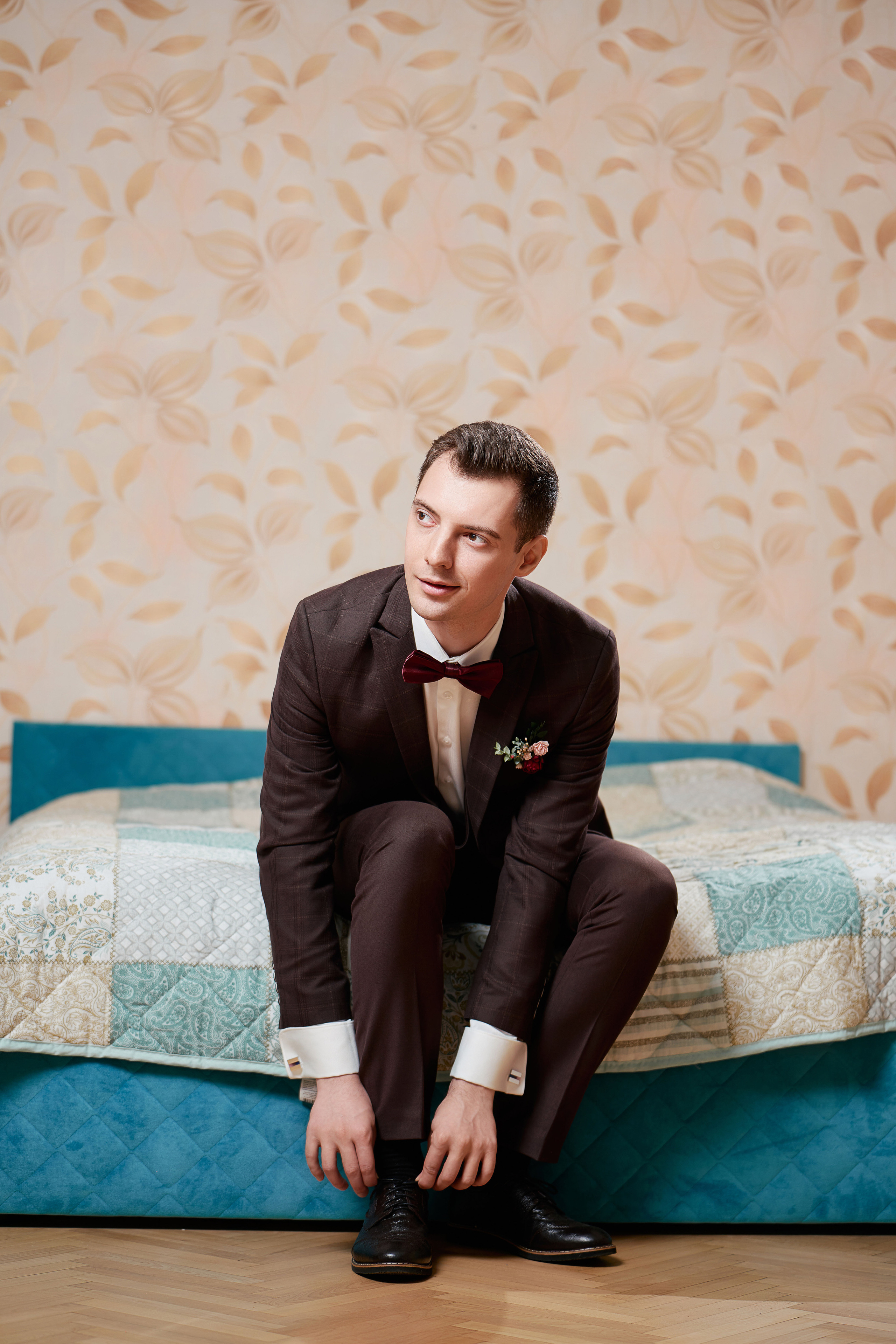 Жених свадебном костюме одевает туфли