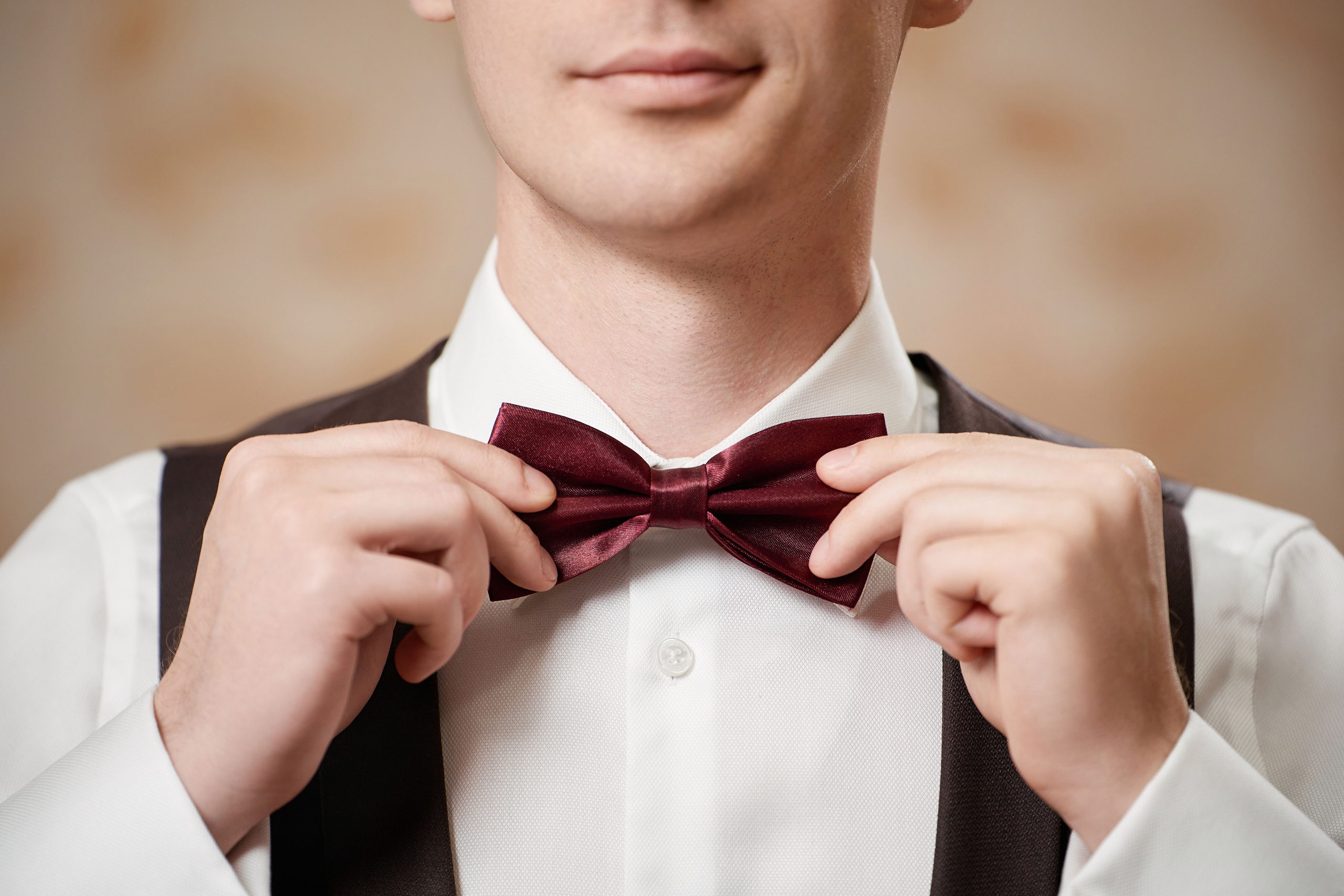 Жених держит бабочку руками