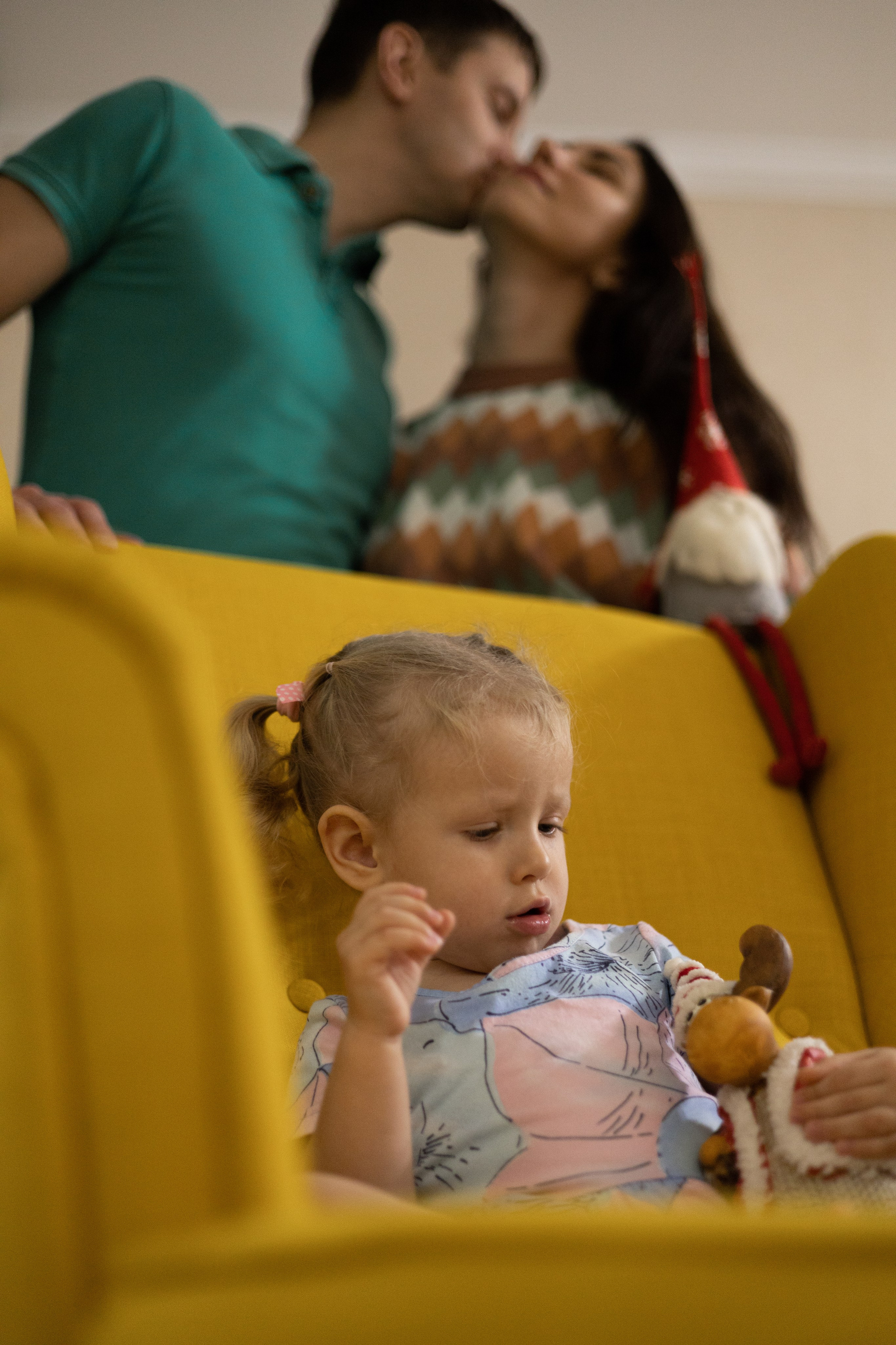 Дочка занята делом пока папа целует маму