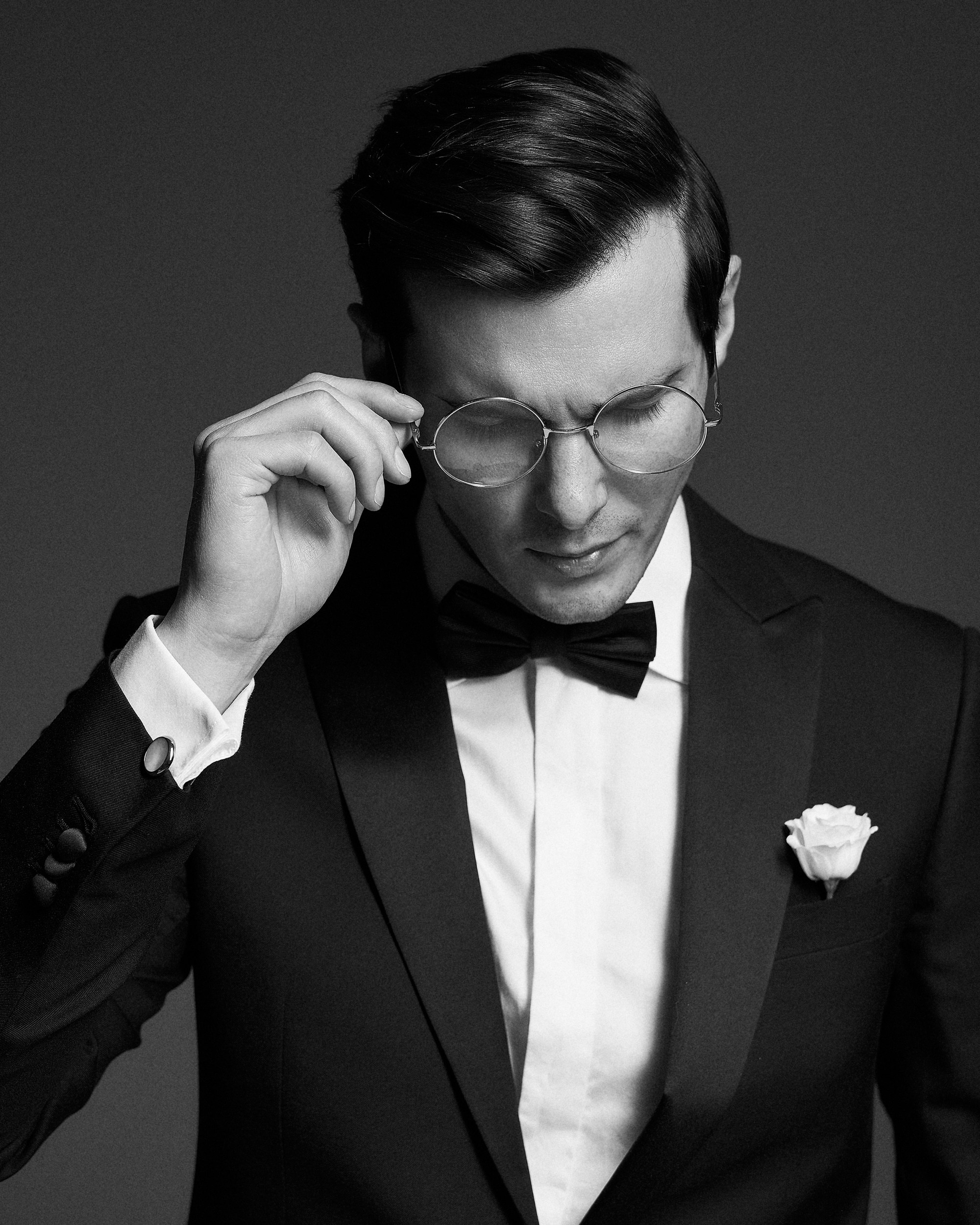 Жених в смокинге на тёмной циклораме. Минимализм, чистота кадра, классический портрет на все времена. Свадебная фотография, фотограф Дмитрий Цветков, СПб