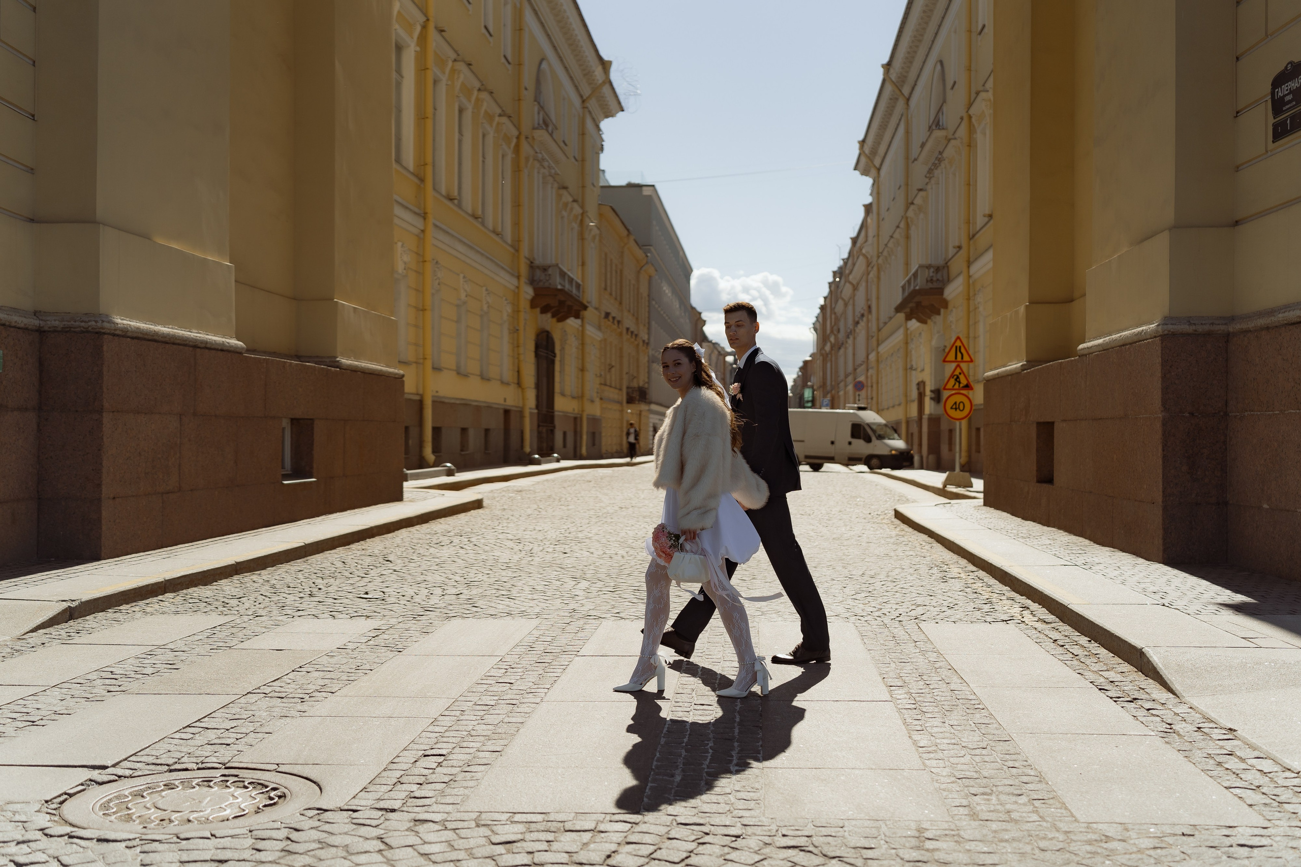 Пара пересекает пустынную улицу в центре Санкт-Петербурга, лёгкий свадебный момент