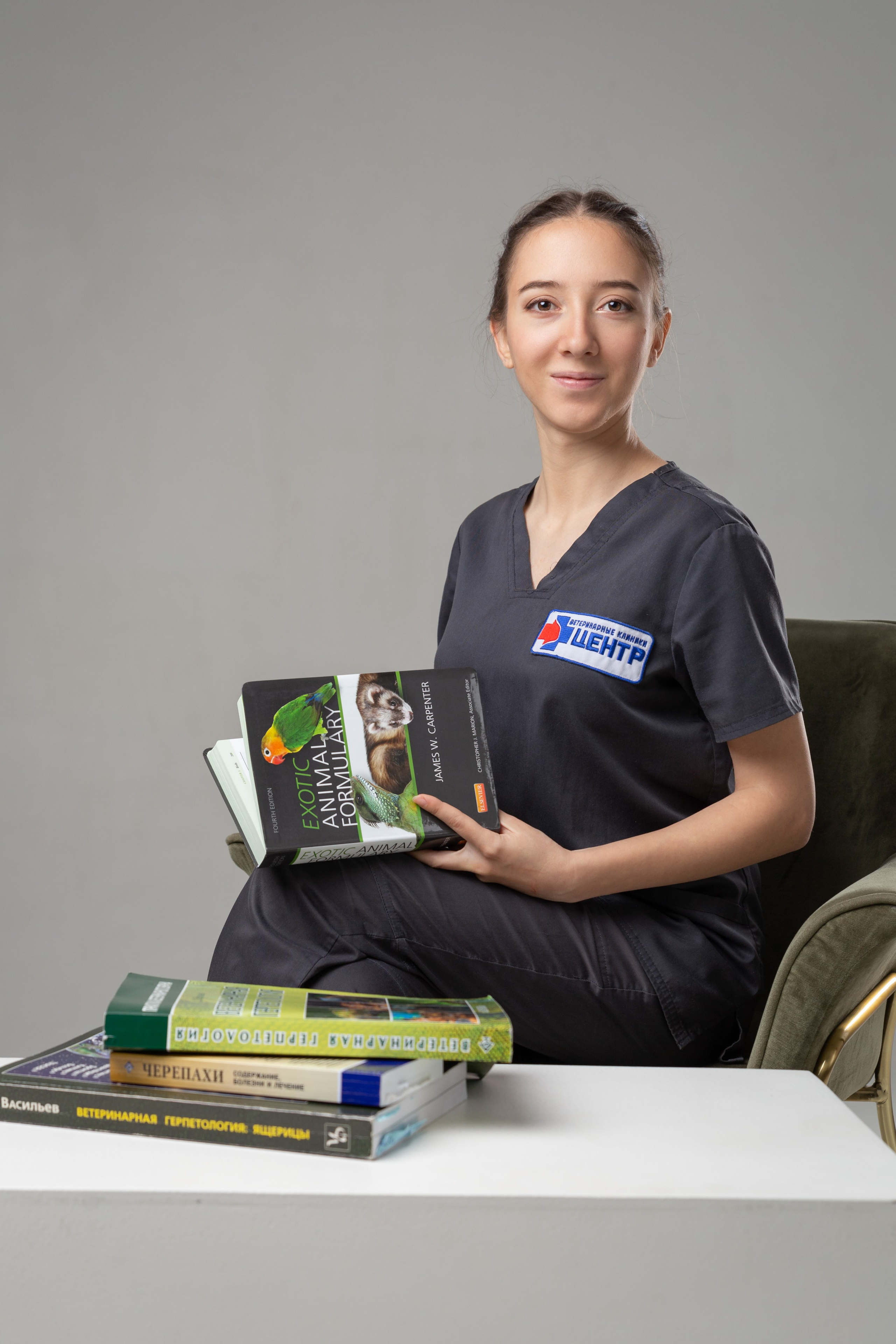Женщина в халате сидит на стуле с книгами