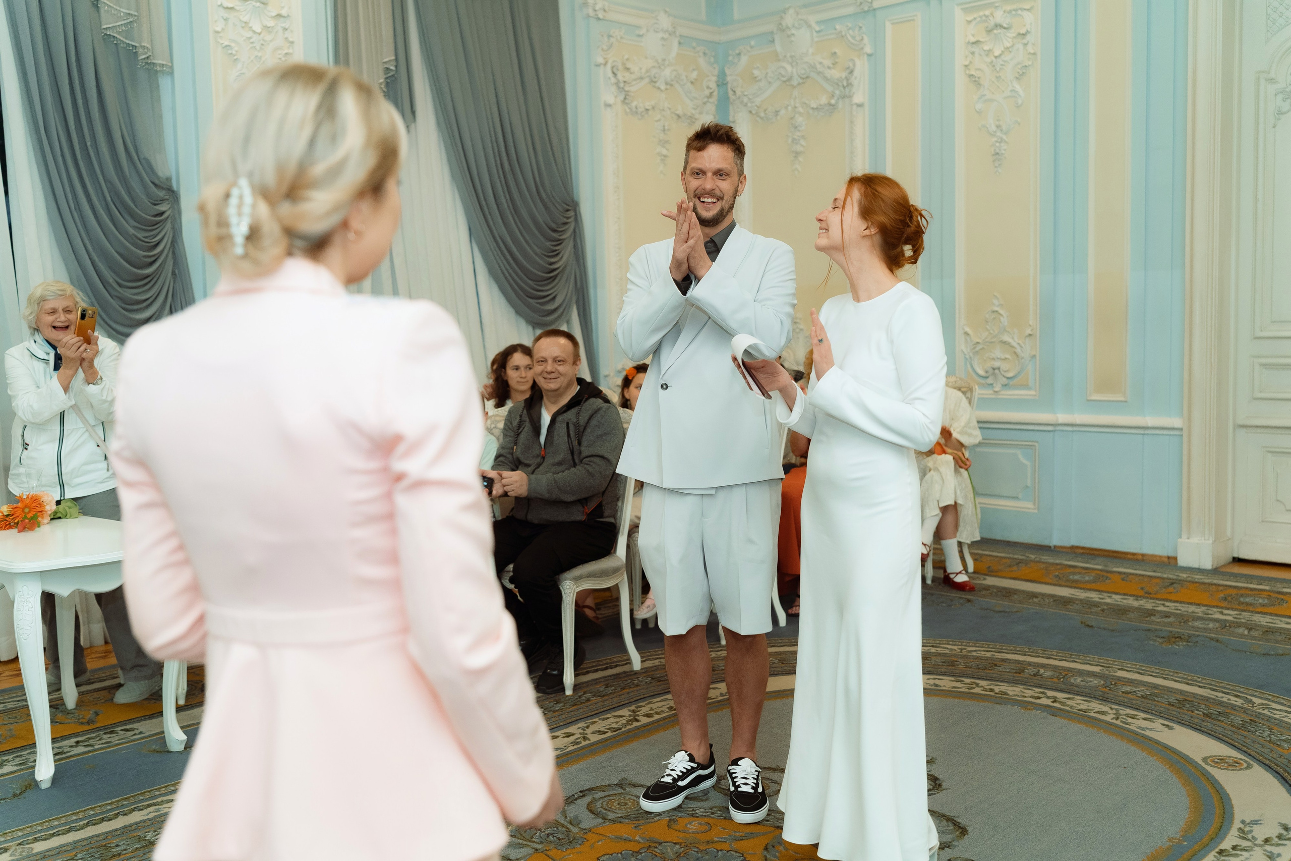 Регистратор вручает свидетельство Марии и Евгению, пара благодарит, гости аплодируют