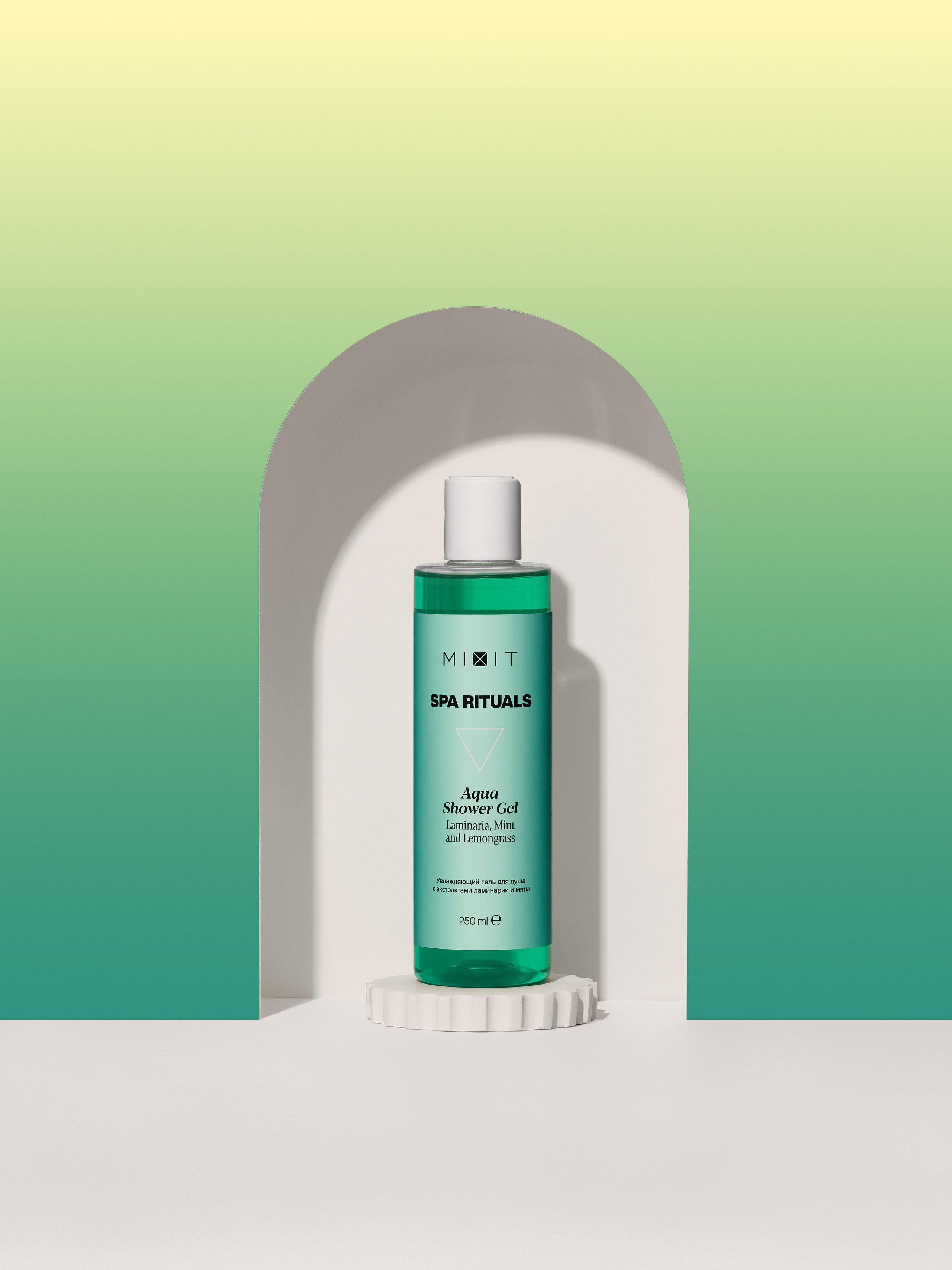 Зеленый флакон геля для душа стоит в арке на бетонной подставке