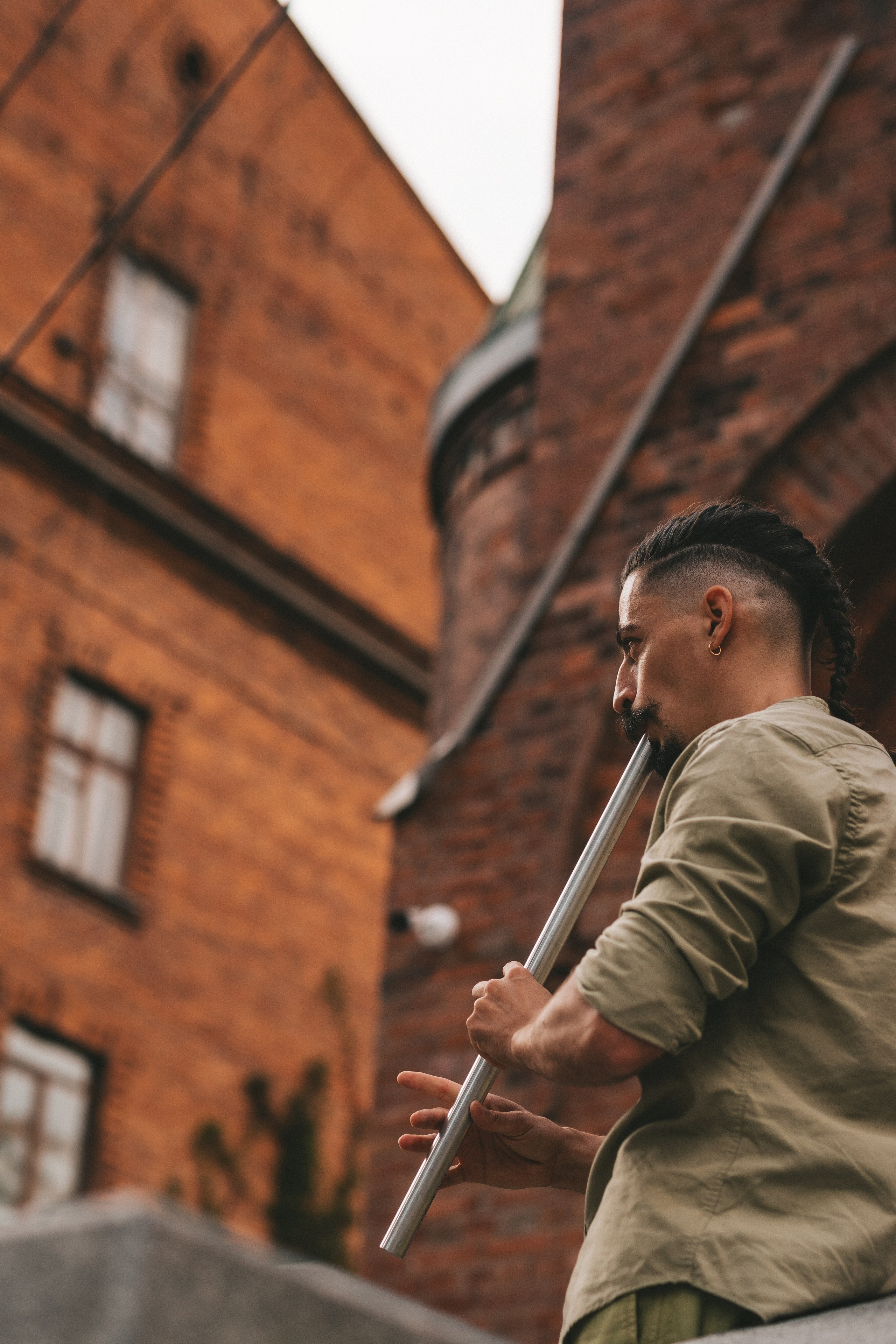 флейтист на фоне кирпичного здания