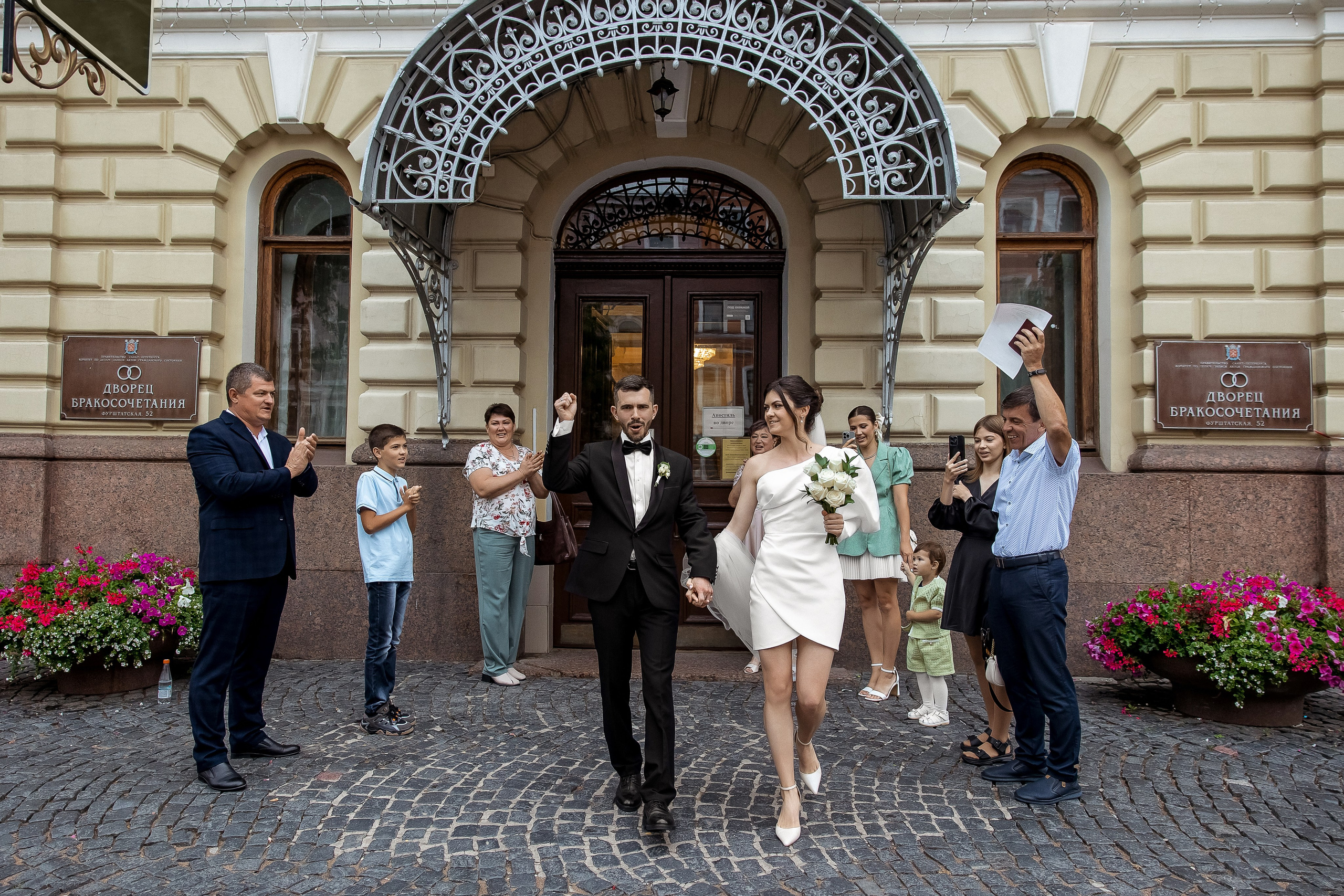 Торжественный выход жениха и невесты из загса под аплодисменты гостей