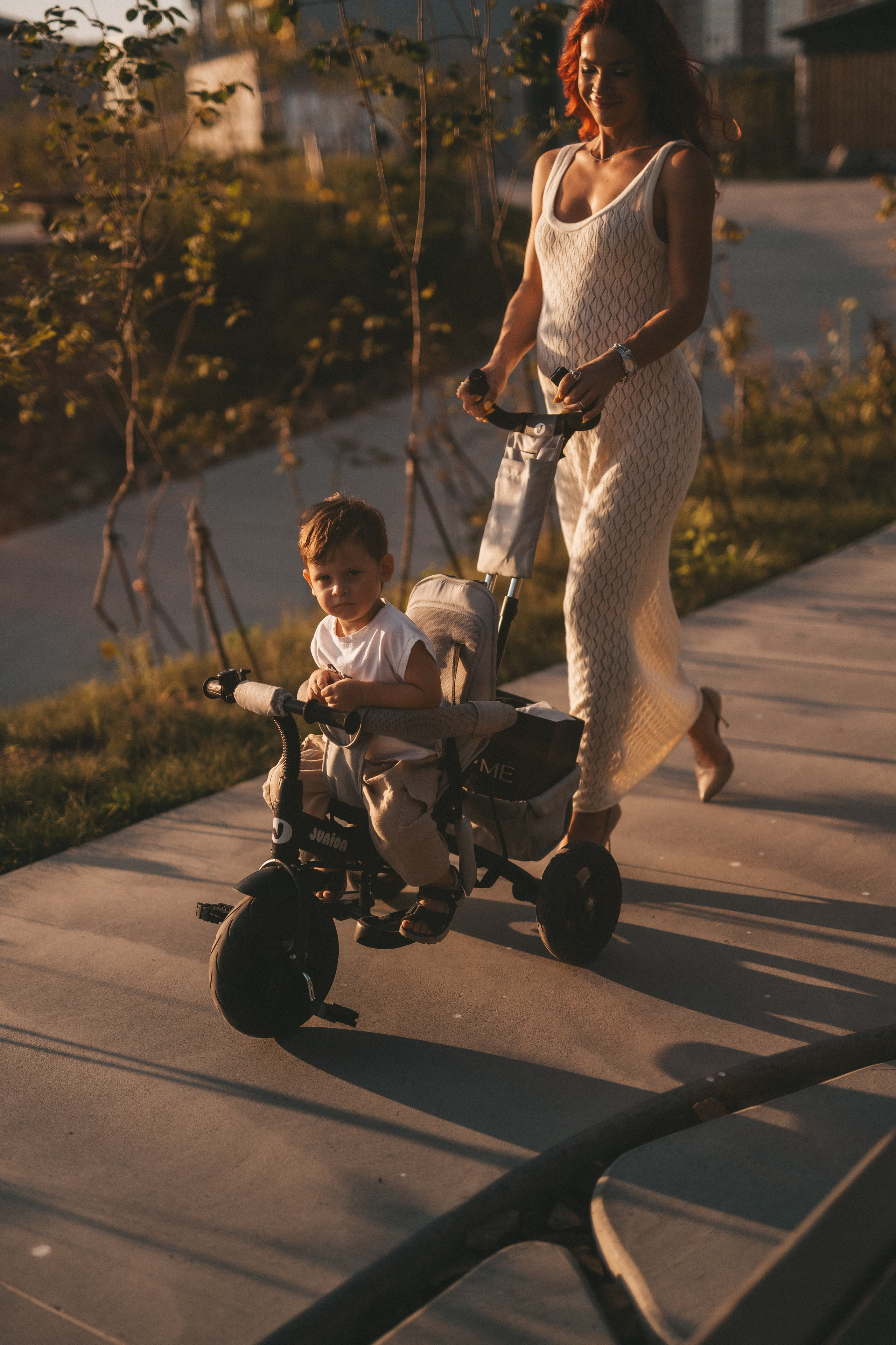 беременная мама везёт сына на велосипеде коляске