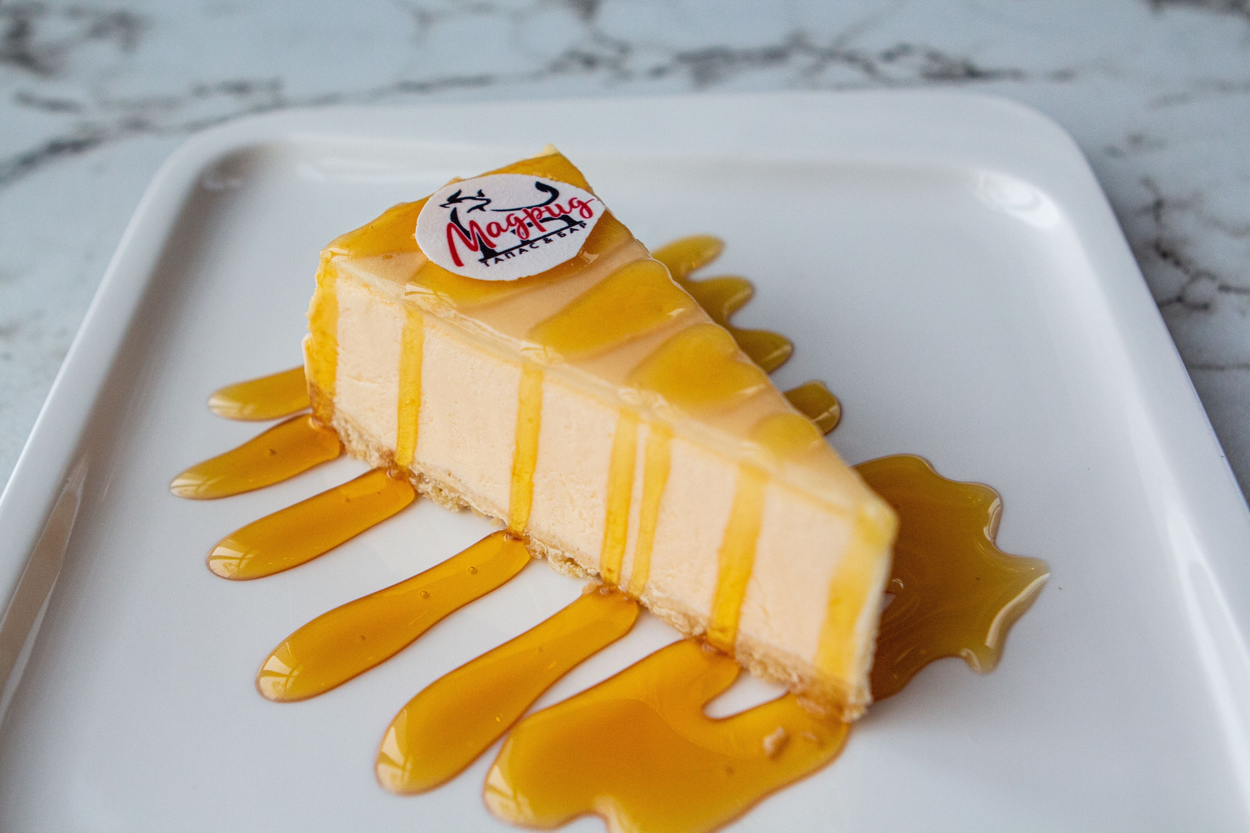 Чизкейк: нежный десерт с воздушным творожным тестом, украшенный свежими ягодами и мятной веточкой на элегантном подносе