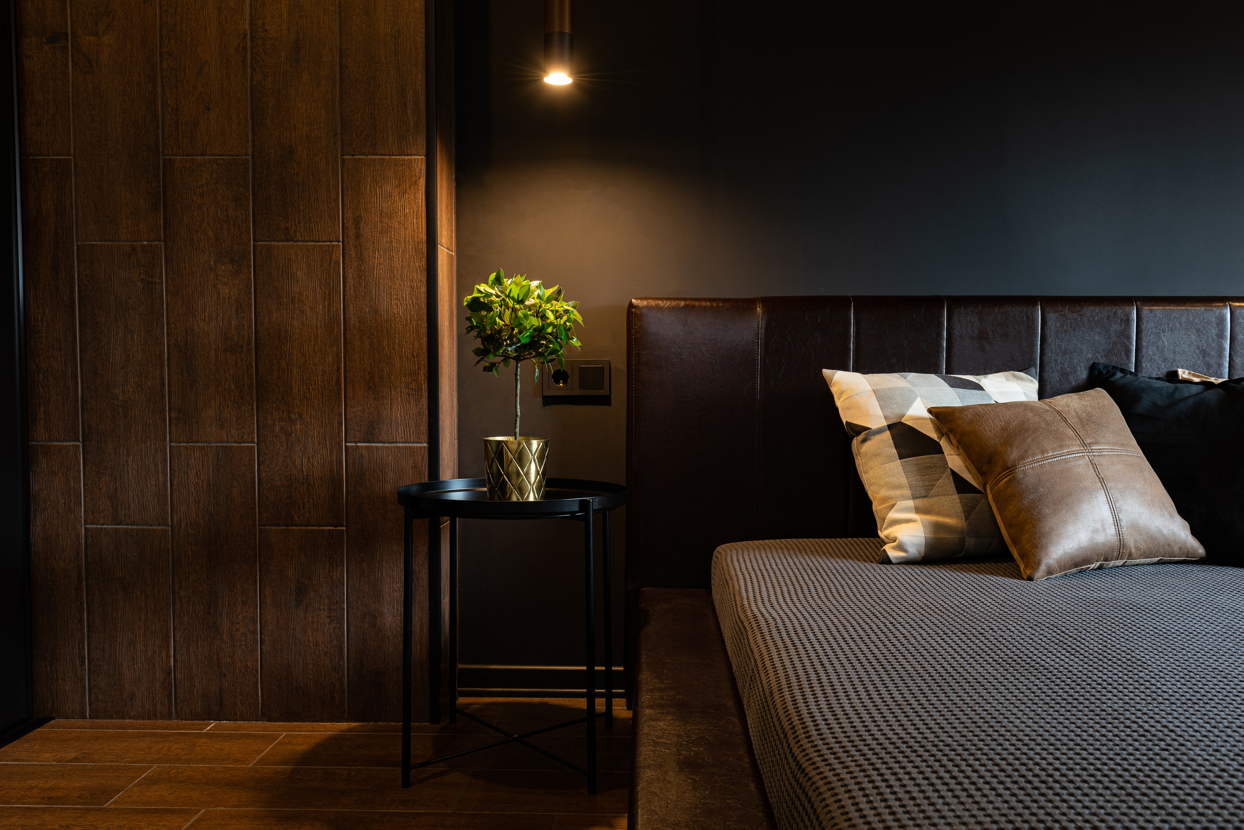 Прикроватная тумбочка в стиле лофт с деревянной столешницей и металлическим каркасом рядом с кроватью