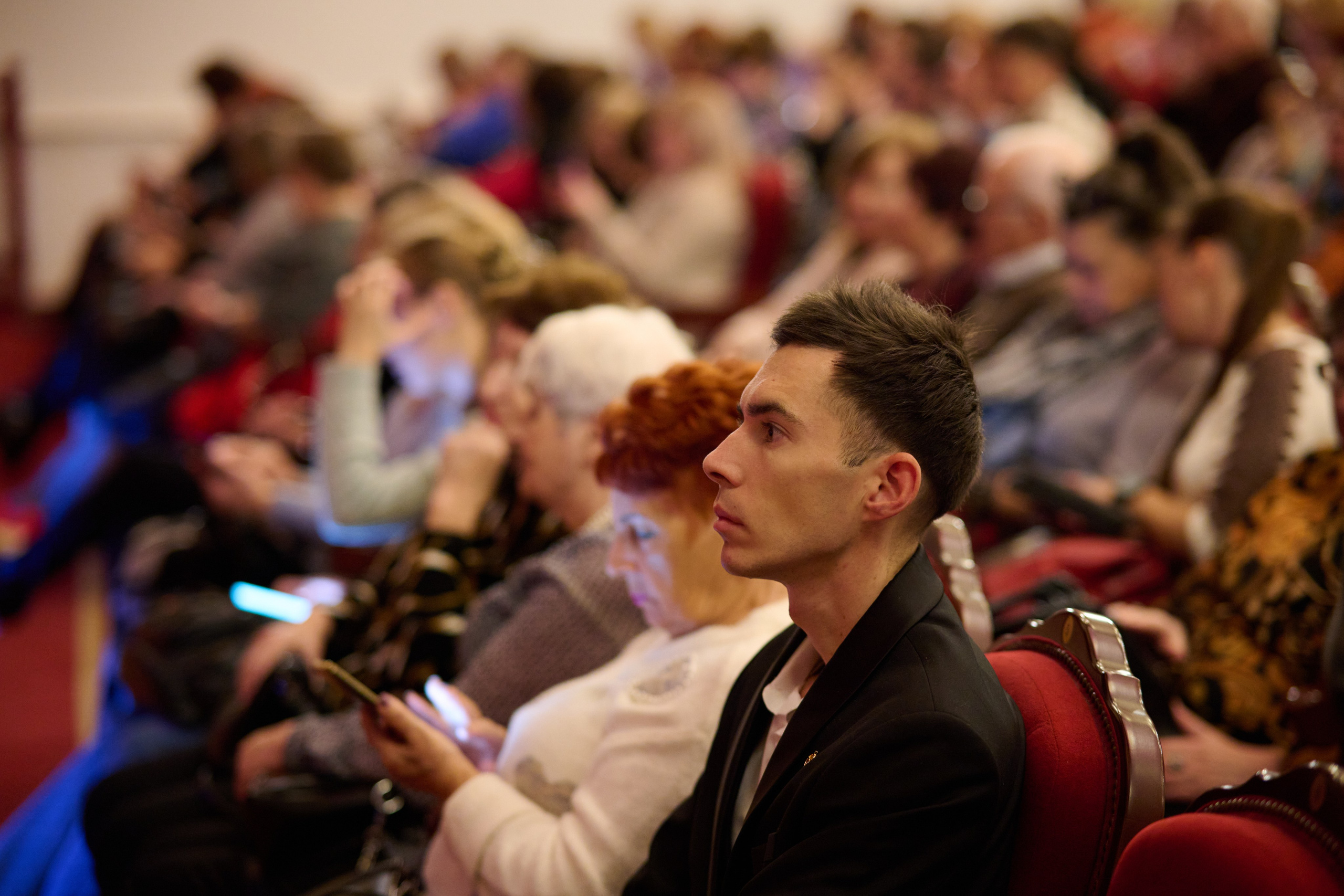 Театральные кресла и зрители во время концерта — съёмка спектакля, тёплая атмосфера зала