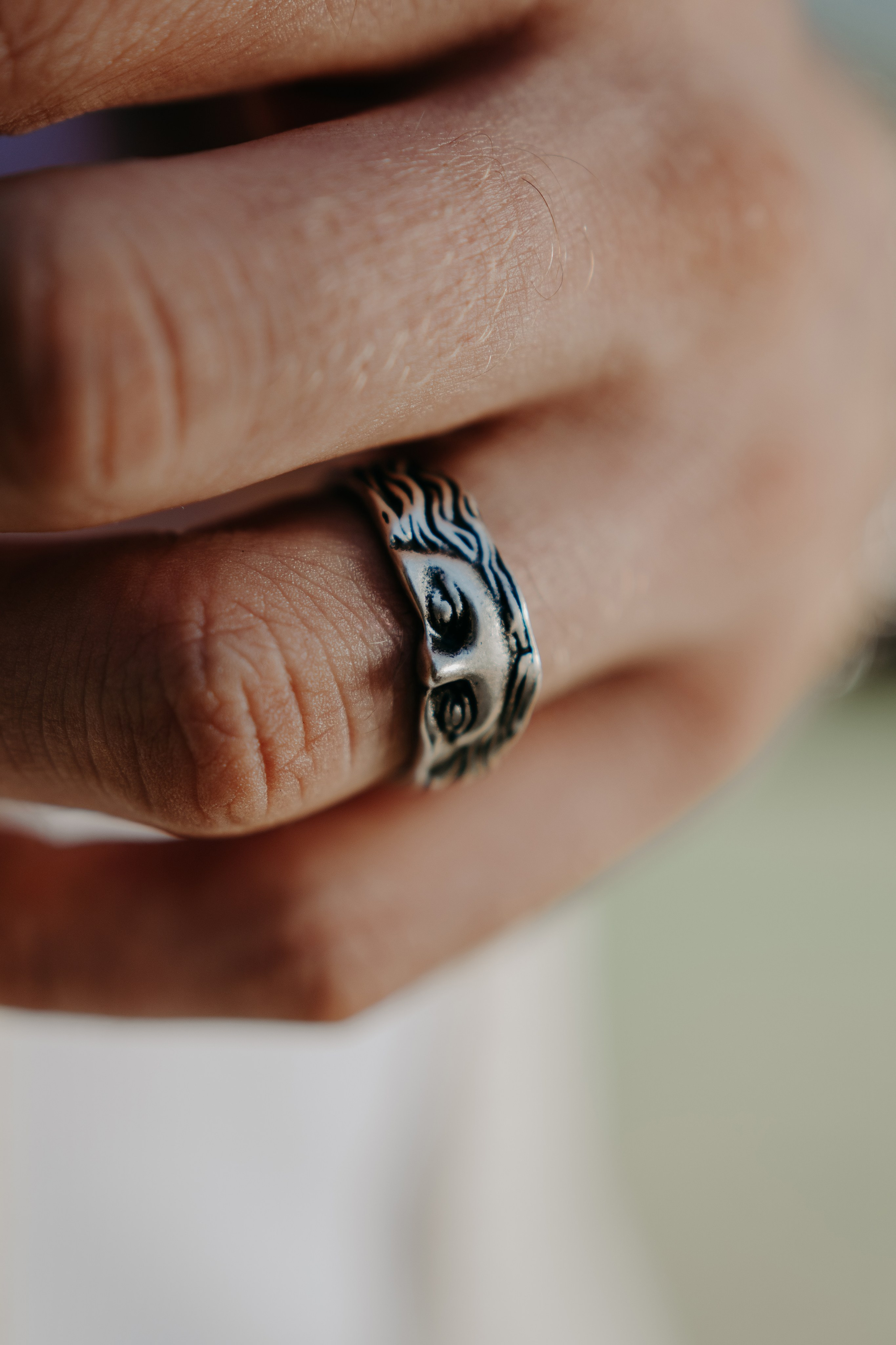 Close-up of a detailed silver ring with a unique design, showcasing craftsmanship.