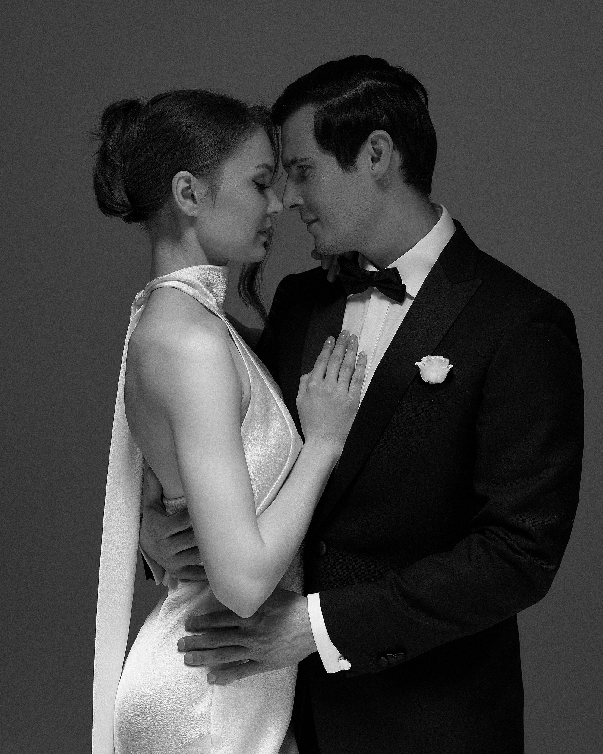 На свадебной съемке в студии жених обнимает невесту на тёмном фоне. Очень чувственно, минималистично, вне времени. Фотограф Дмитрий Цветков, Санкт-Петербург