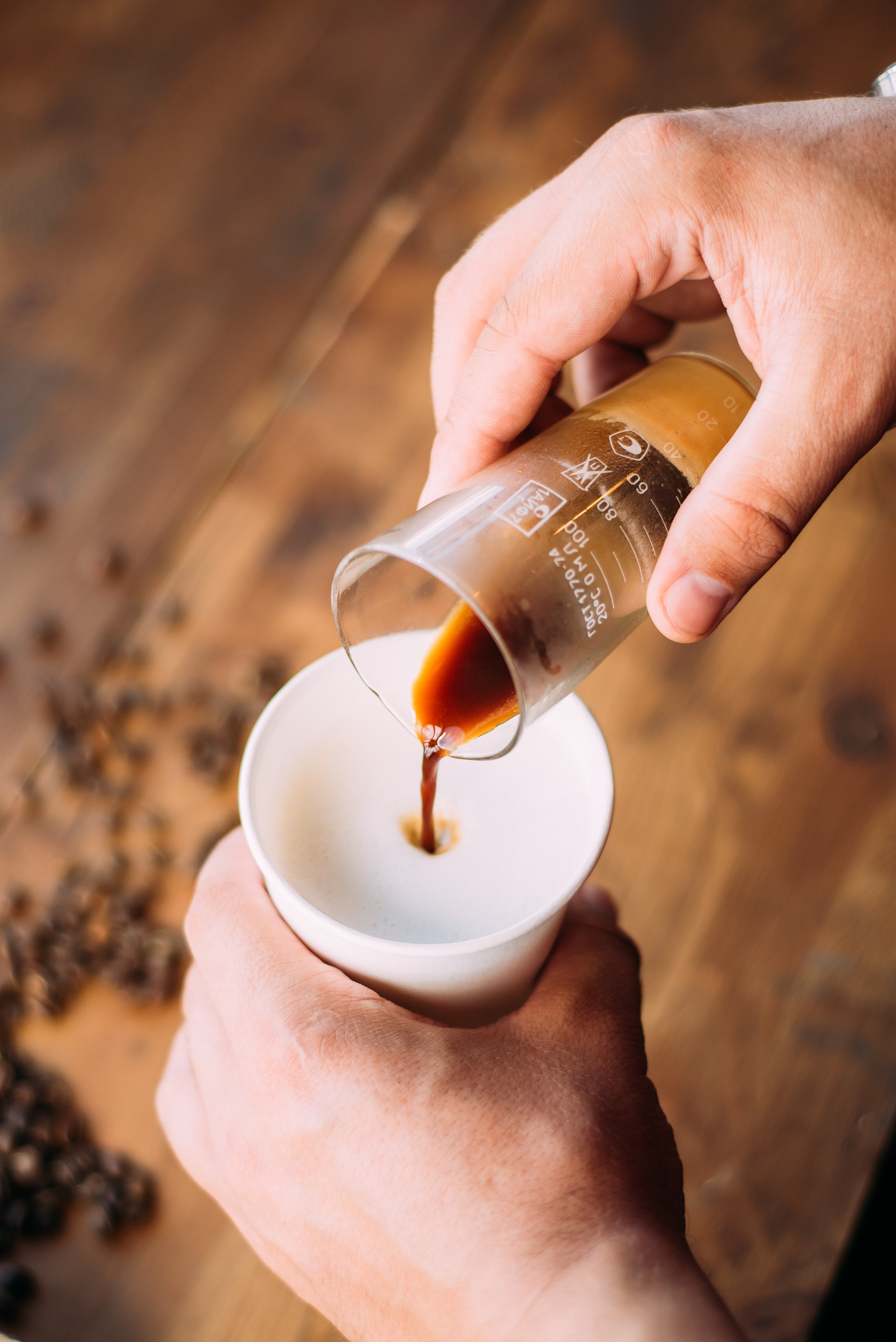 Руки человека наливают кофе в стакан