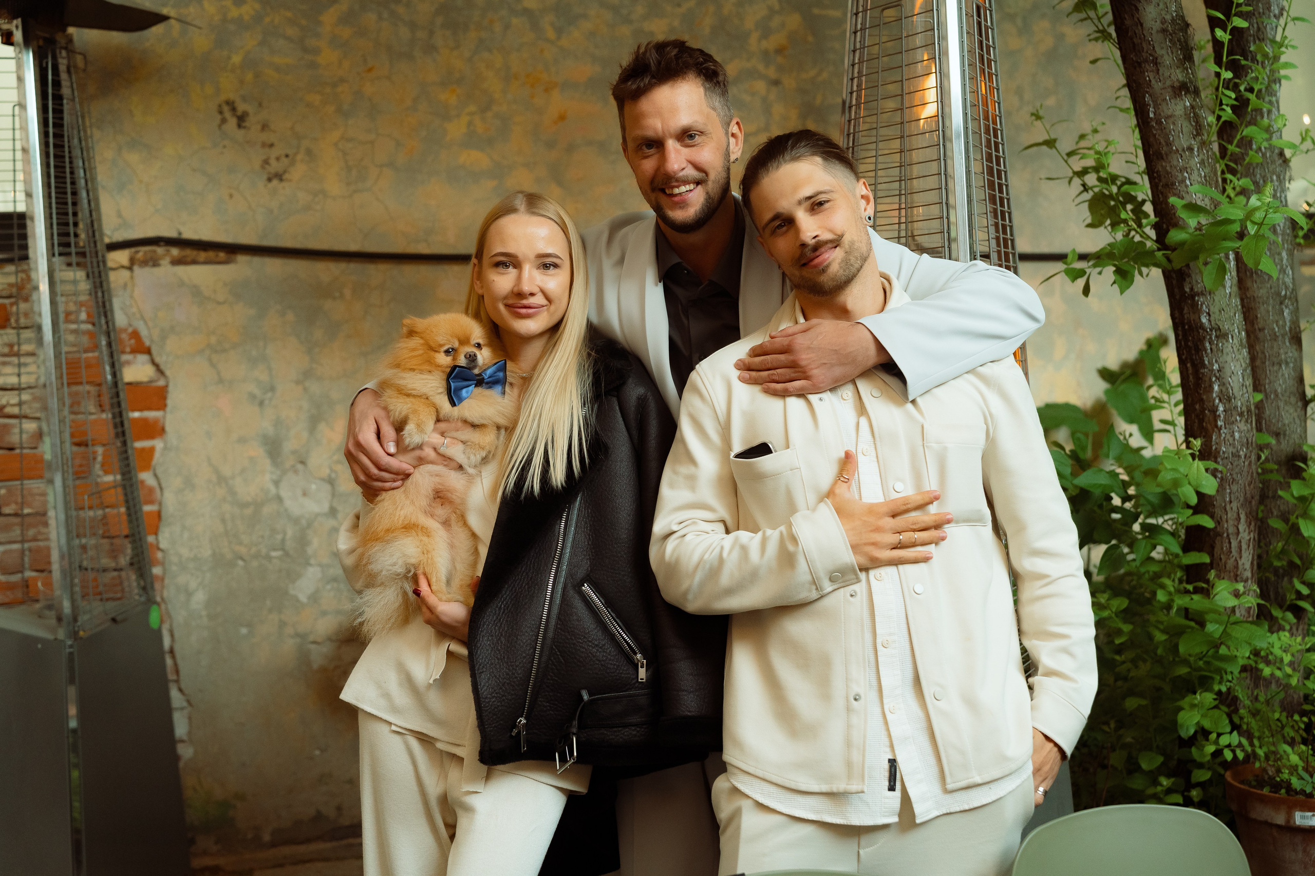Мария, Евгений и друг обнимают рыжего шпица на террасе кафе