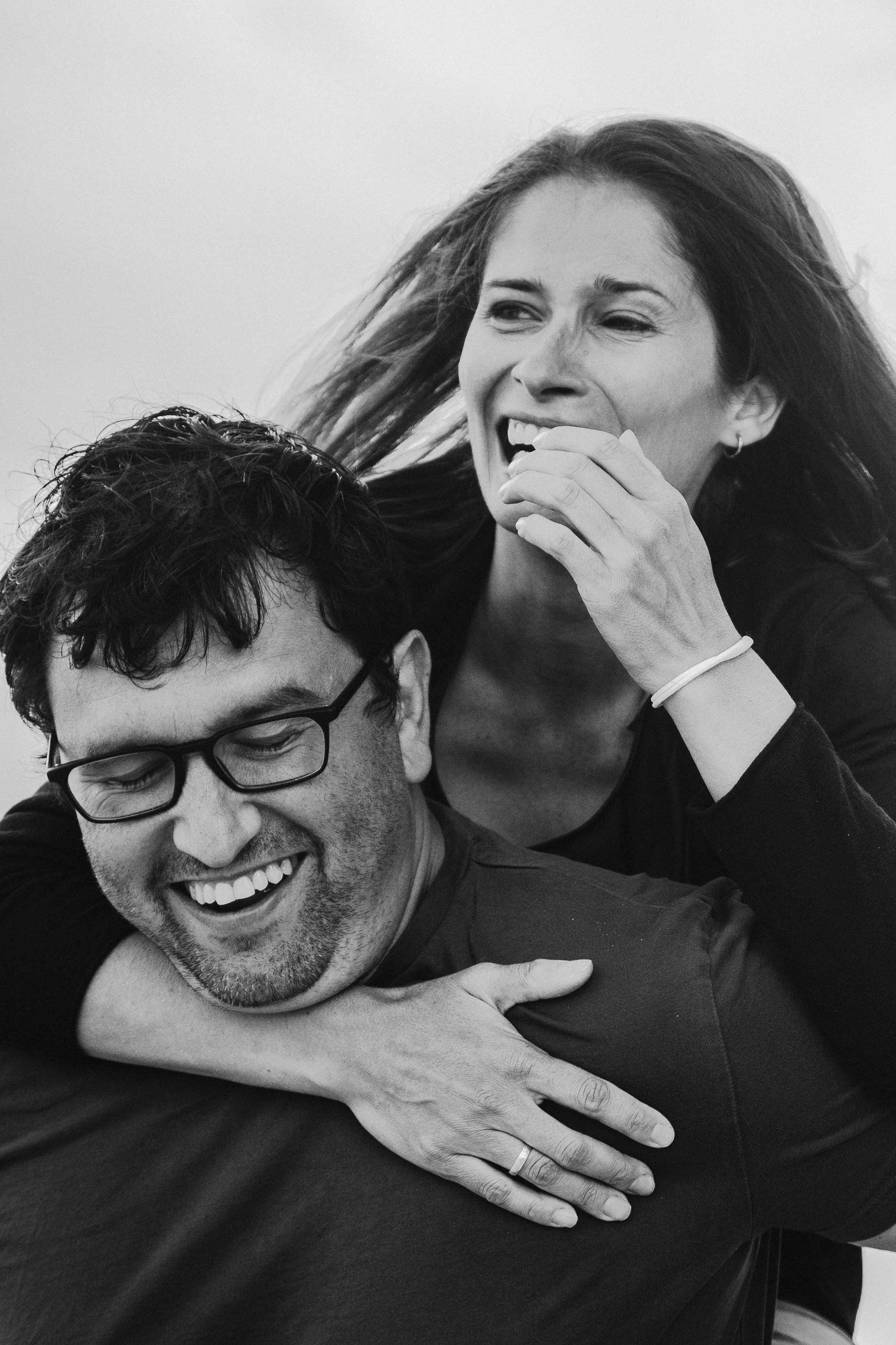 Parents share a romantic moment as they walk along a picturesque Tuscan path.