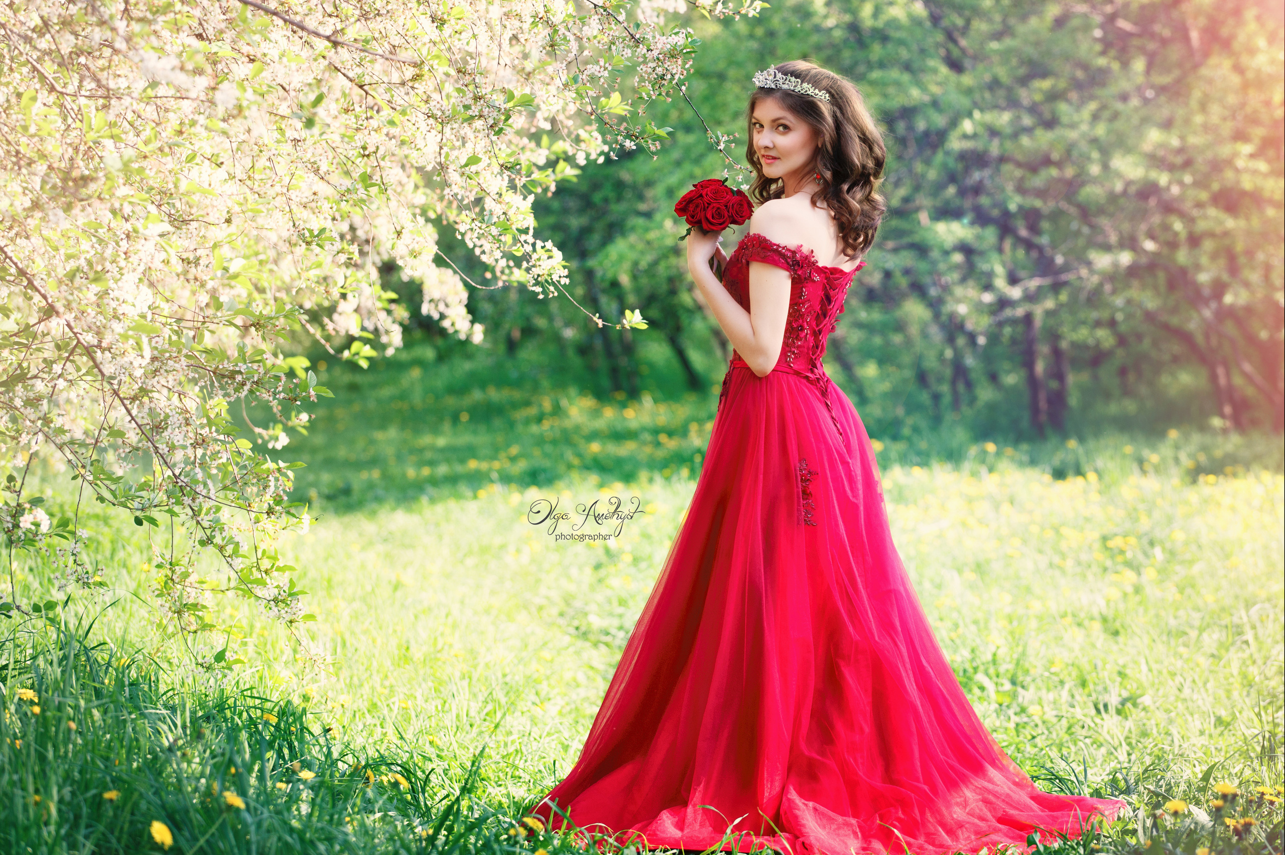 Девушка в красном платье на фоне цветущих винешь