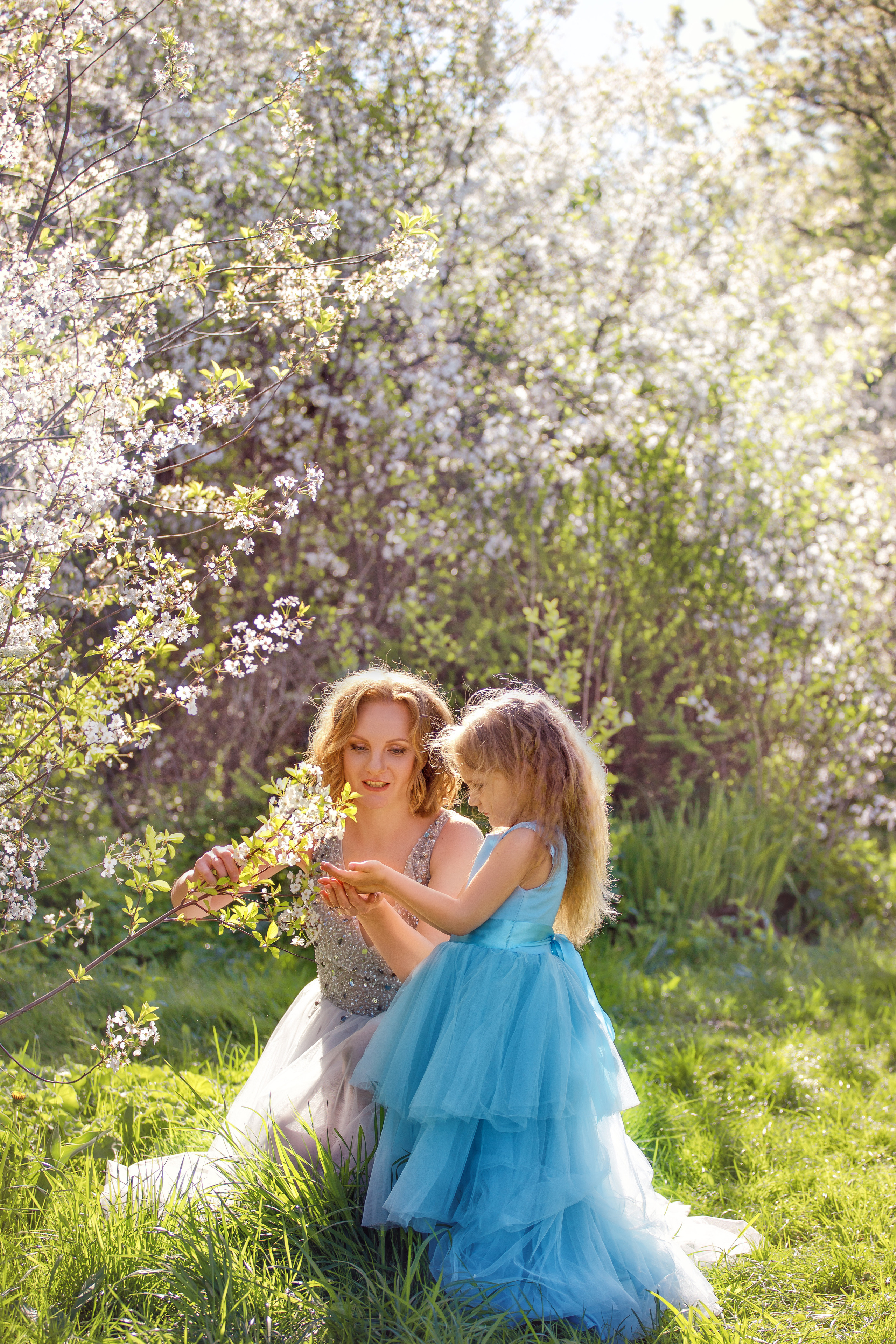 Мама и дочка в фоне цветущей вишни в Коломенском парке