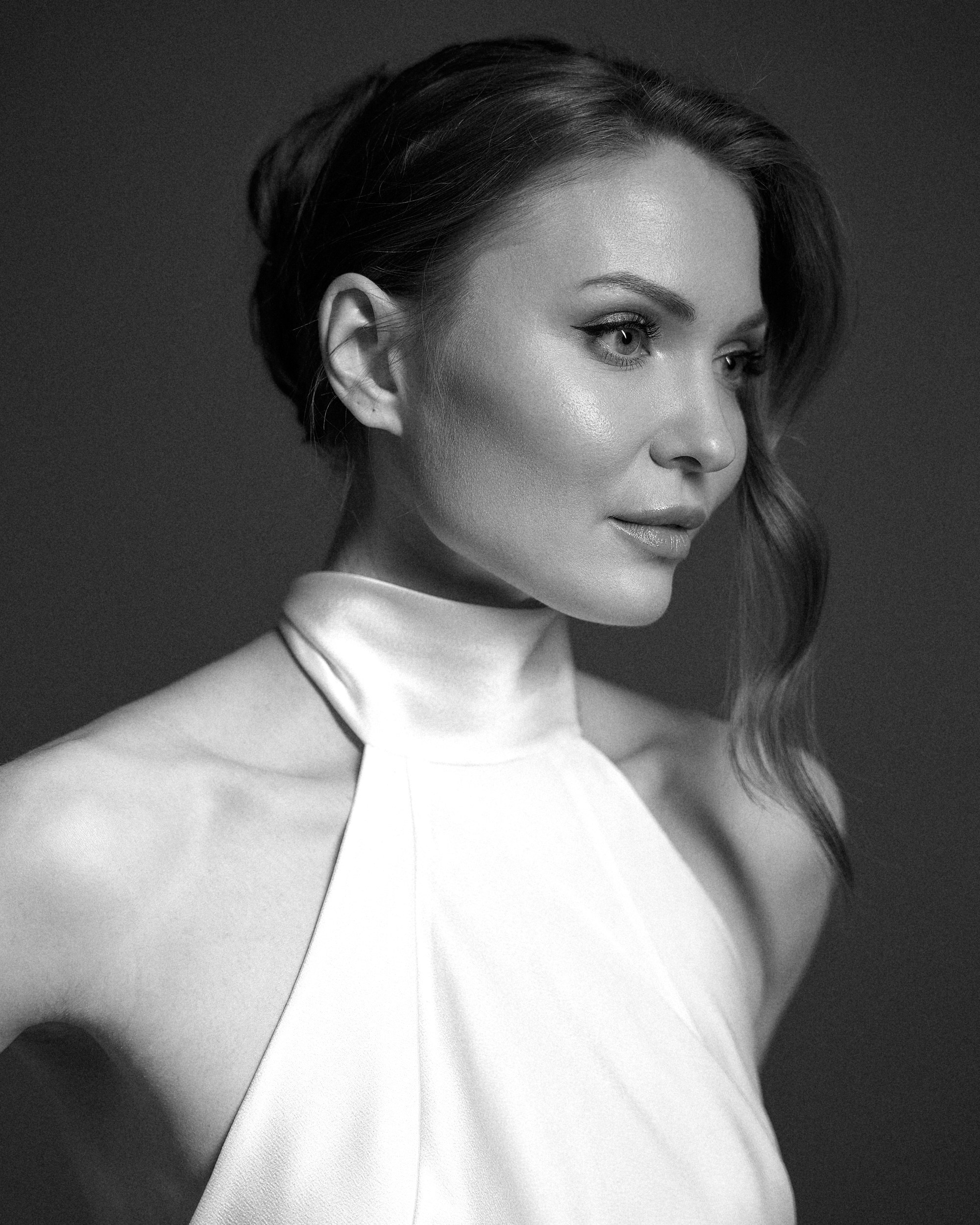 Портрет невесты на тёмном фоне студии. Свет мягко лежит на лице, платье и фата создают воздушный силуэт. Свадебная съемка в минималистичном стиле, фотограф Дмитрий Цветков, Санкт-Петербург