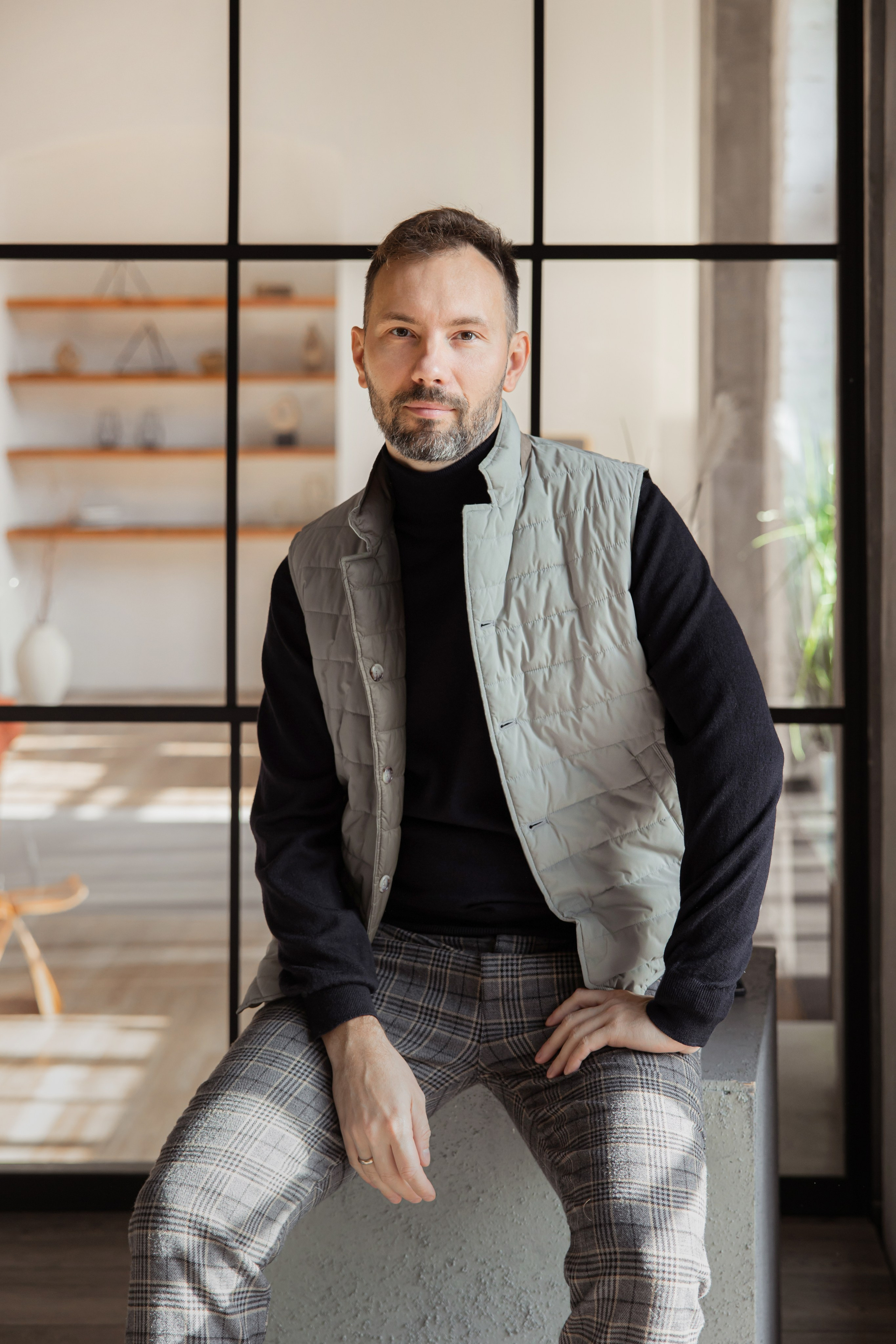 Бизнес-портрет руководителя мужчины в серой жилетке в интерьере