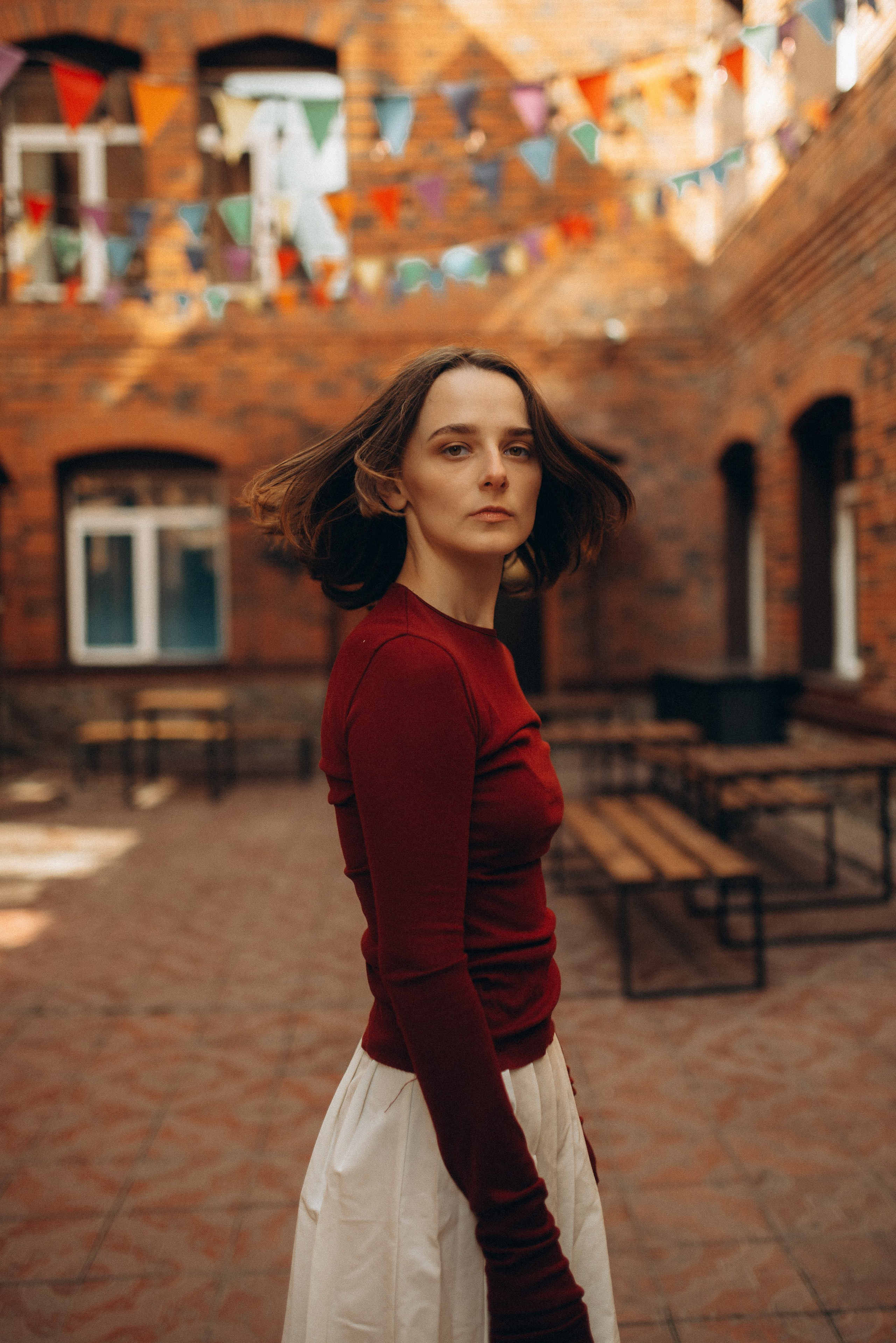 Женский портрет в красной водолазке и белой юбке, контрастное фото на фоне кирпичной кладки и металлических конструкций. Фотосессия в Новосибирске. 1.