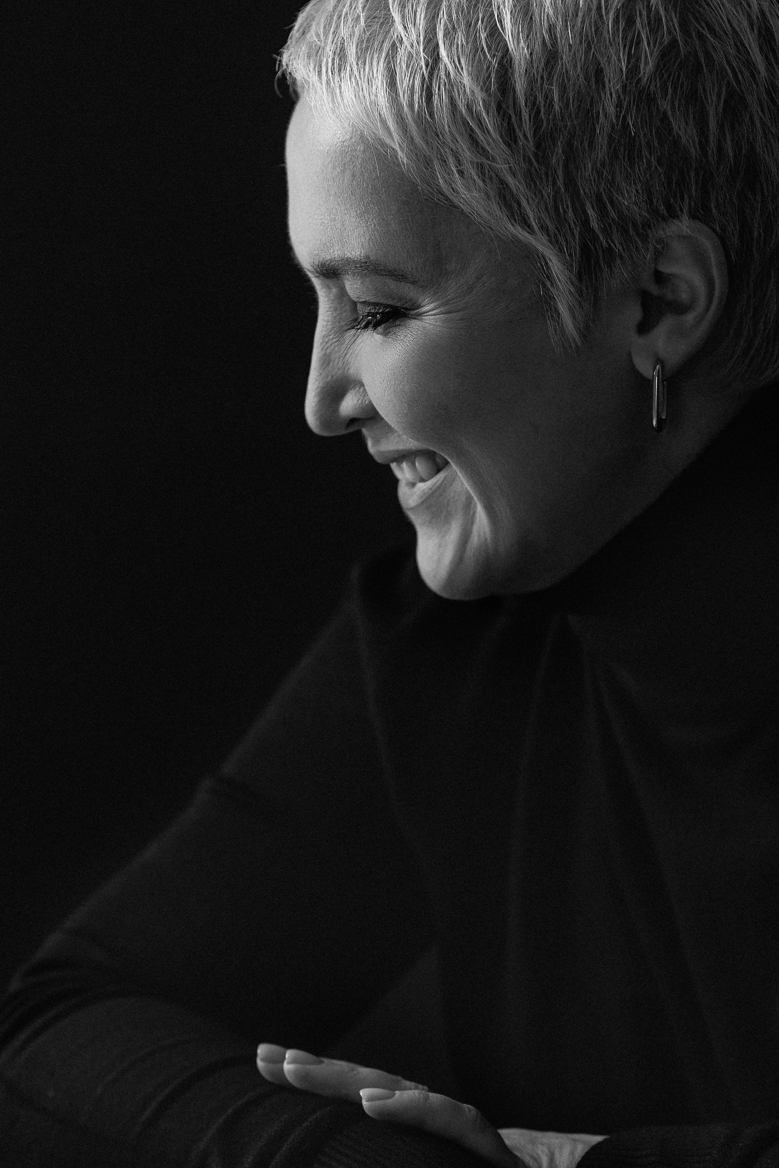 Чёрно-белый портрет женщины в студии, естественная поза, мягкий свет, минималистичный фон