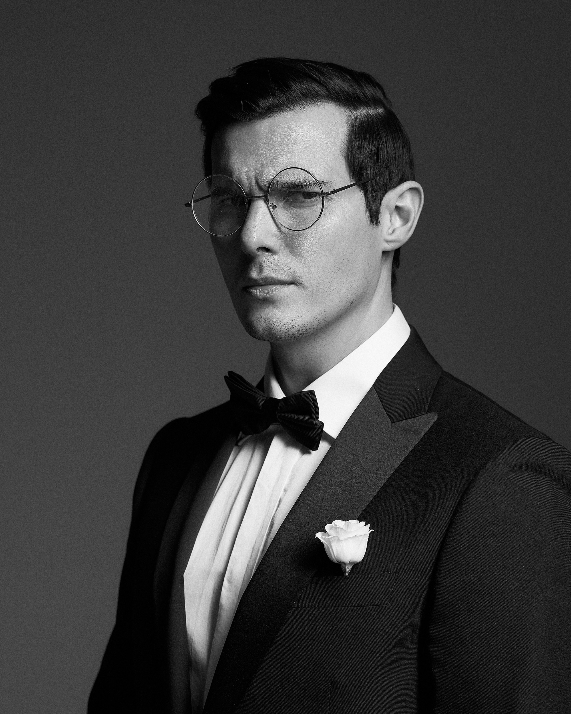 Жених в смокинге на чёрном фоне. Крупный план, драматичный свет, уверенный образ. Свадебная фотография, минимализм, фотограф Дмитрий Цветков, СПб