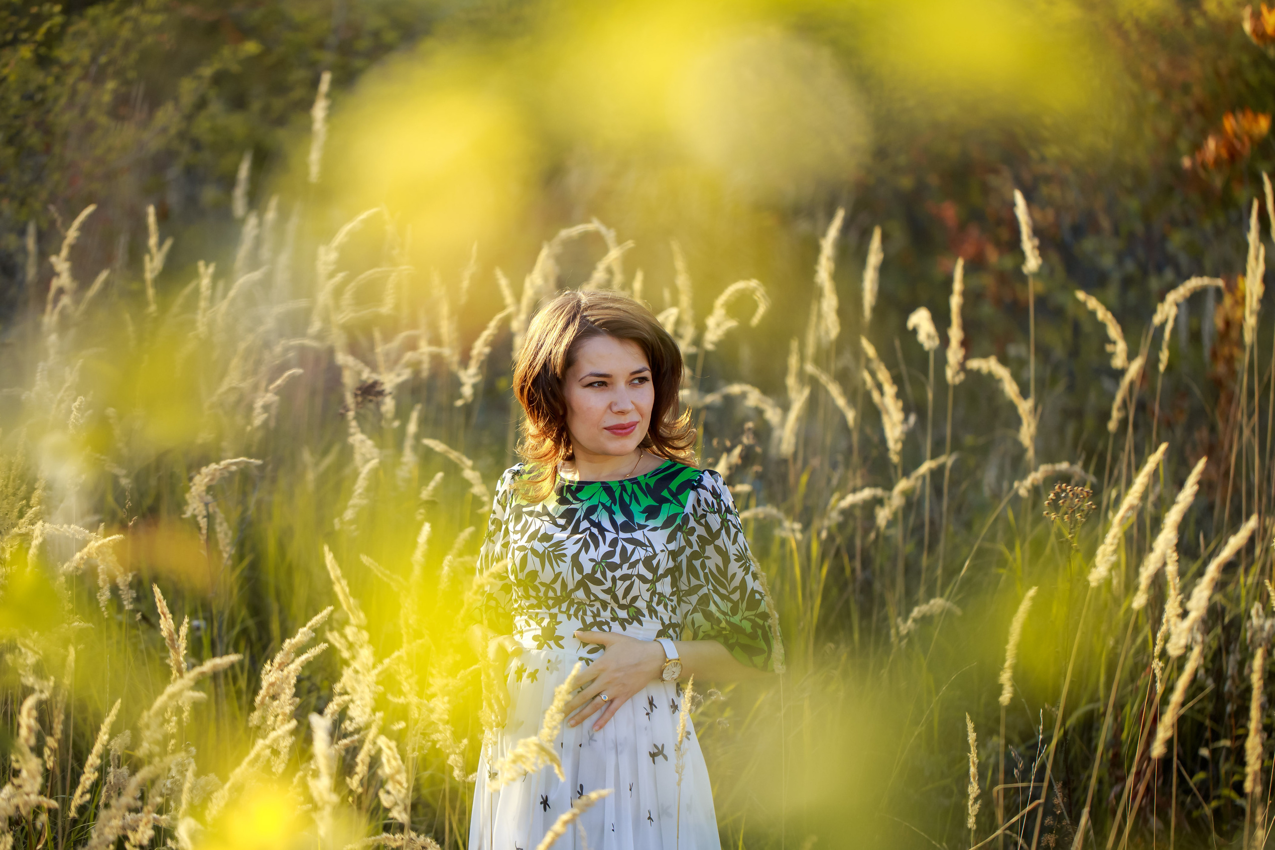 Осенняя фотосессия беременной будущая мама в красивом платье стоит в колосьях