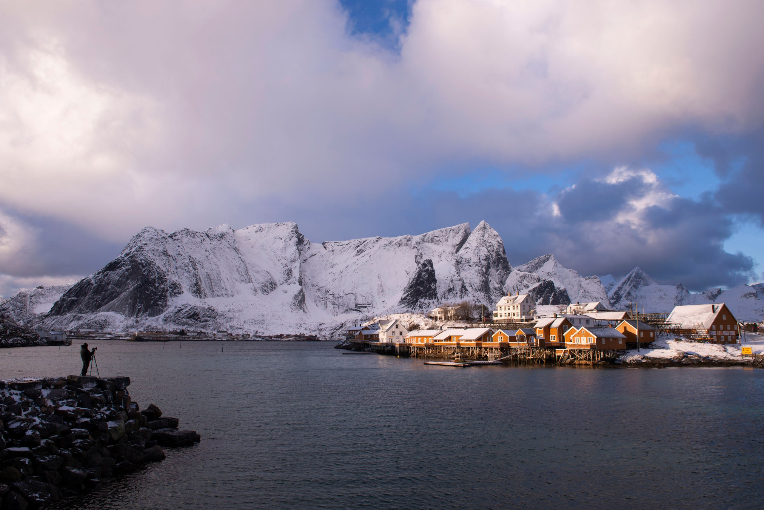 Зимний пейзаж норвежской рыбацкой деревни Сакрисёй на фоне заснеженных гор.