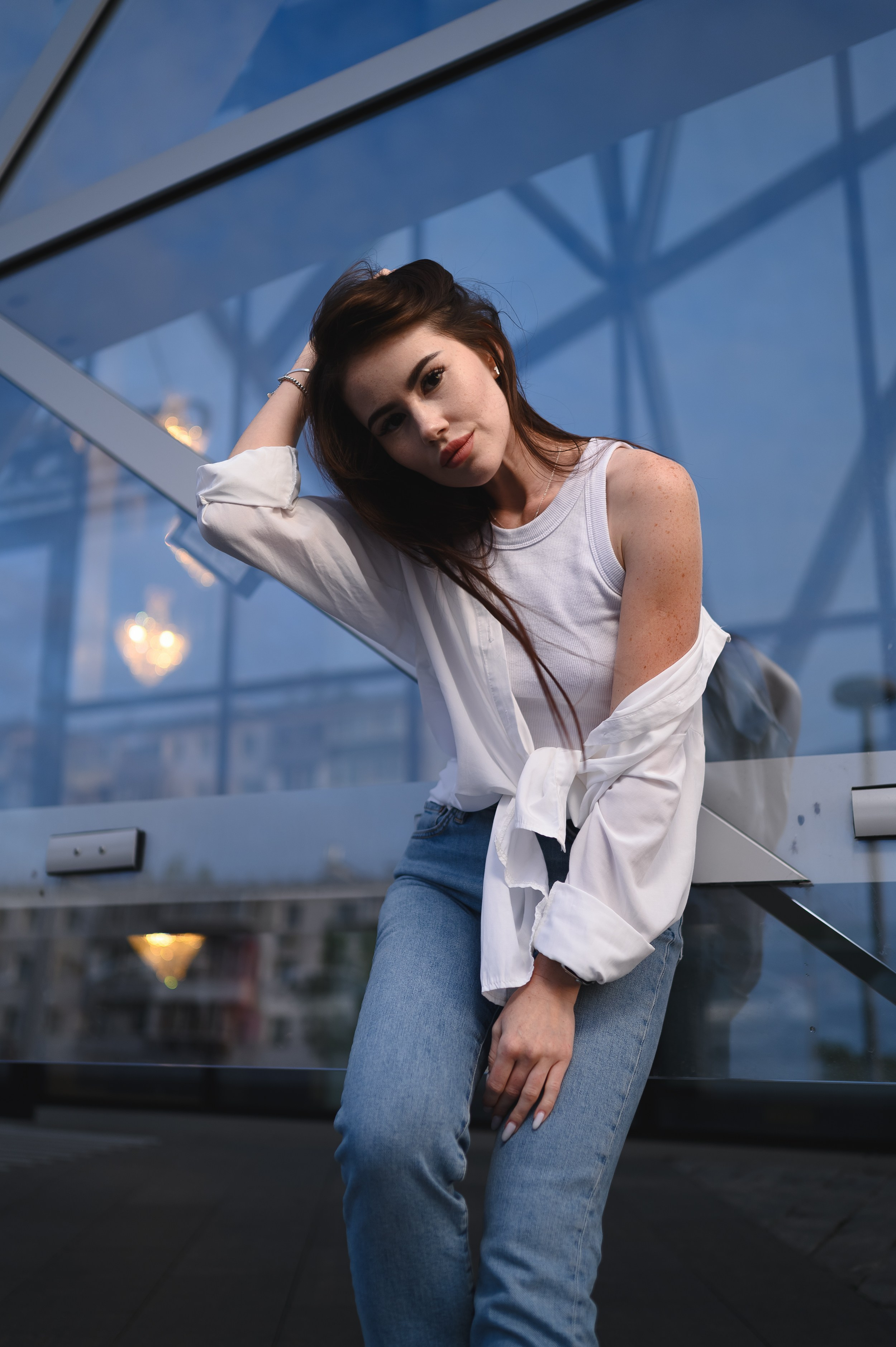 Вечерняя фотосессия девушки в белой рубашке у современного здания театра Камала в центре Казани