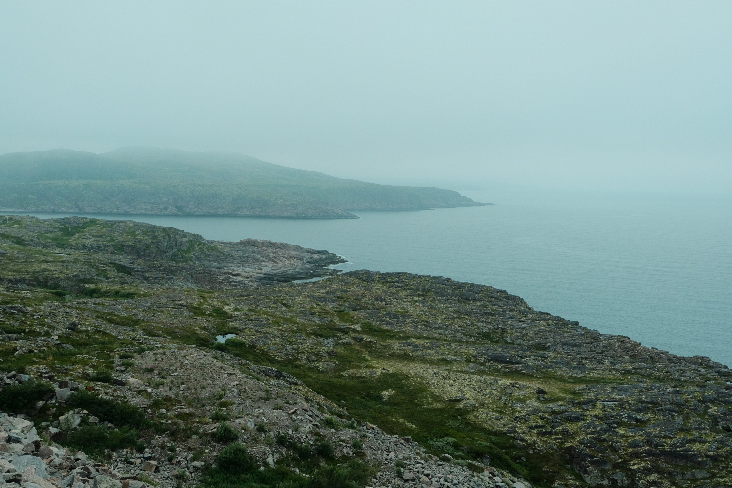 View from the cape of the Barents Sea and the bay in the fog