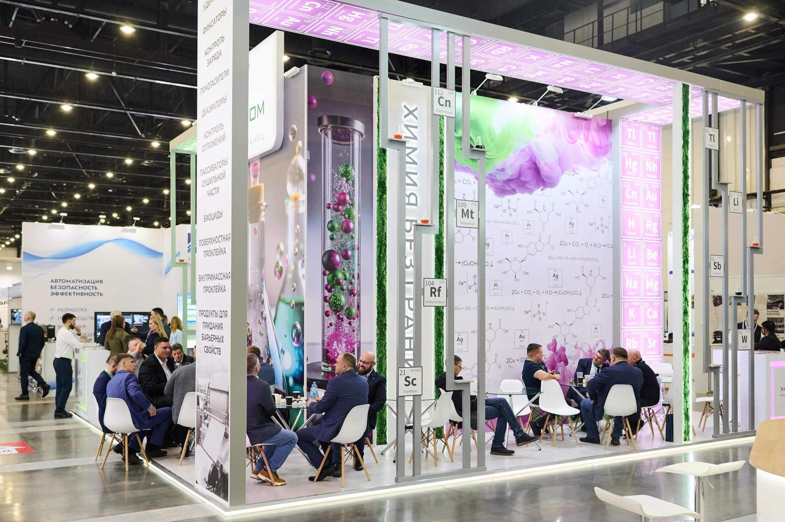 Большой стенд с зоной для общения: люди за столиками ведут переговоры.