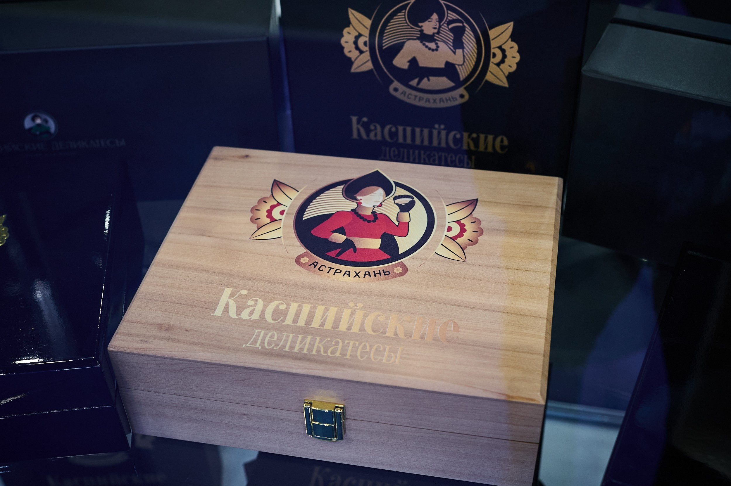 Коробка «Каспийские деликатесы» крупным планом на выставке Seafood Expo Russia 2025. Репортажная съёмка экспозиции в Экспофоруме, Санкт‑Петербург.