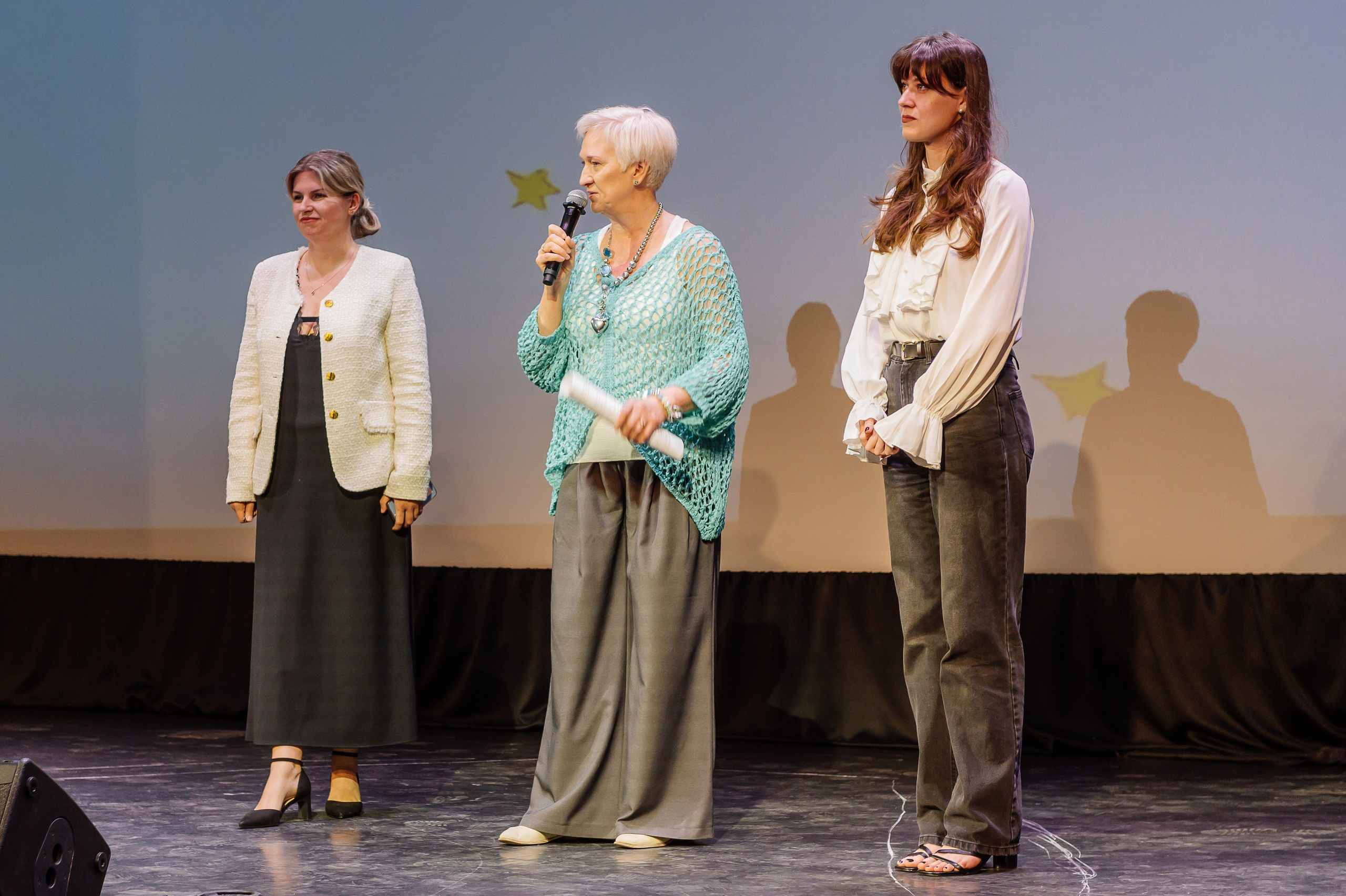 директор выступает с речью на сцене