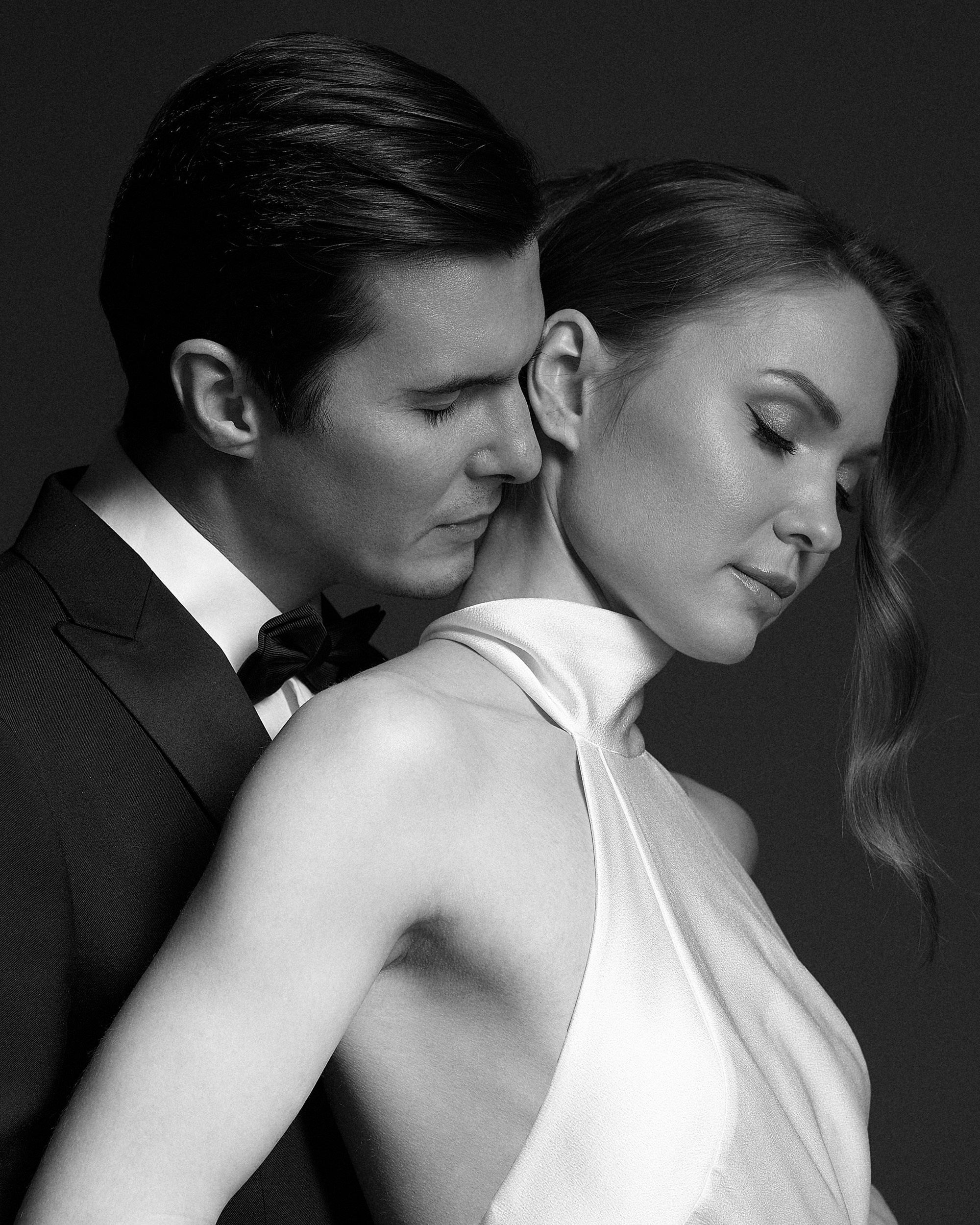 Объятие на тёмном фоне. Жених прижимает невесту к себе, она закрыла глаза. В этом кадре — всё: нежность, доверие, чувственность. Свадебная фотография, фотограф Дмитрий Цветков, Санкт-Петербург