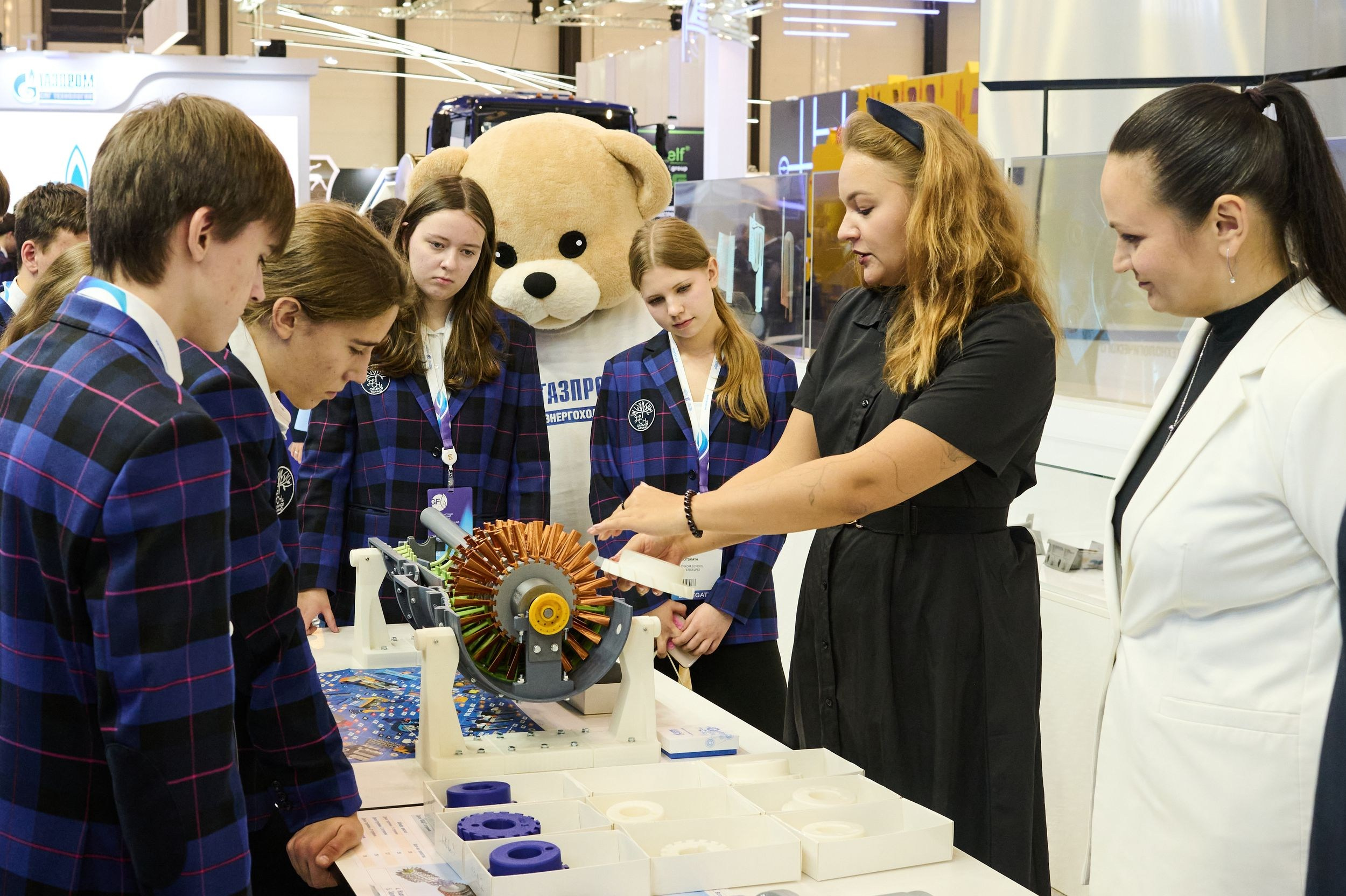 Средний план: школьники слушают объяснения о технологиях на выставочном стенде Петербургского международного газового форума 2025 в Экспофоруме
