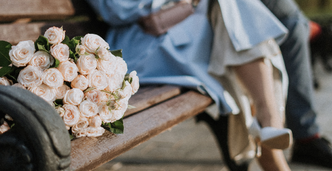 Парень с девушкой фотографируются на скамейке перед свадьбой