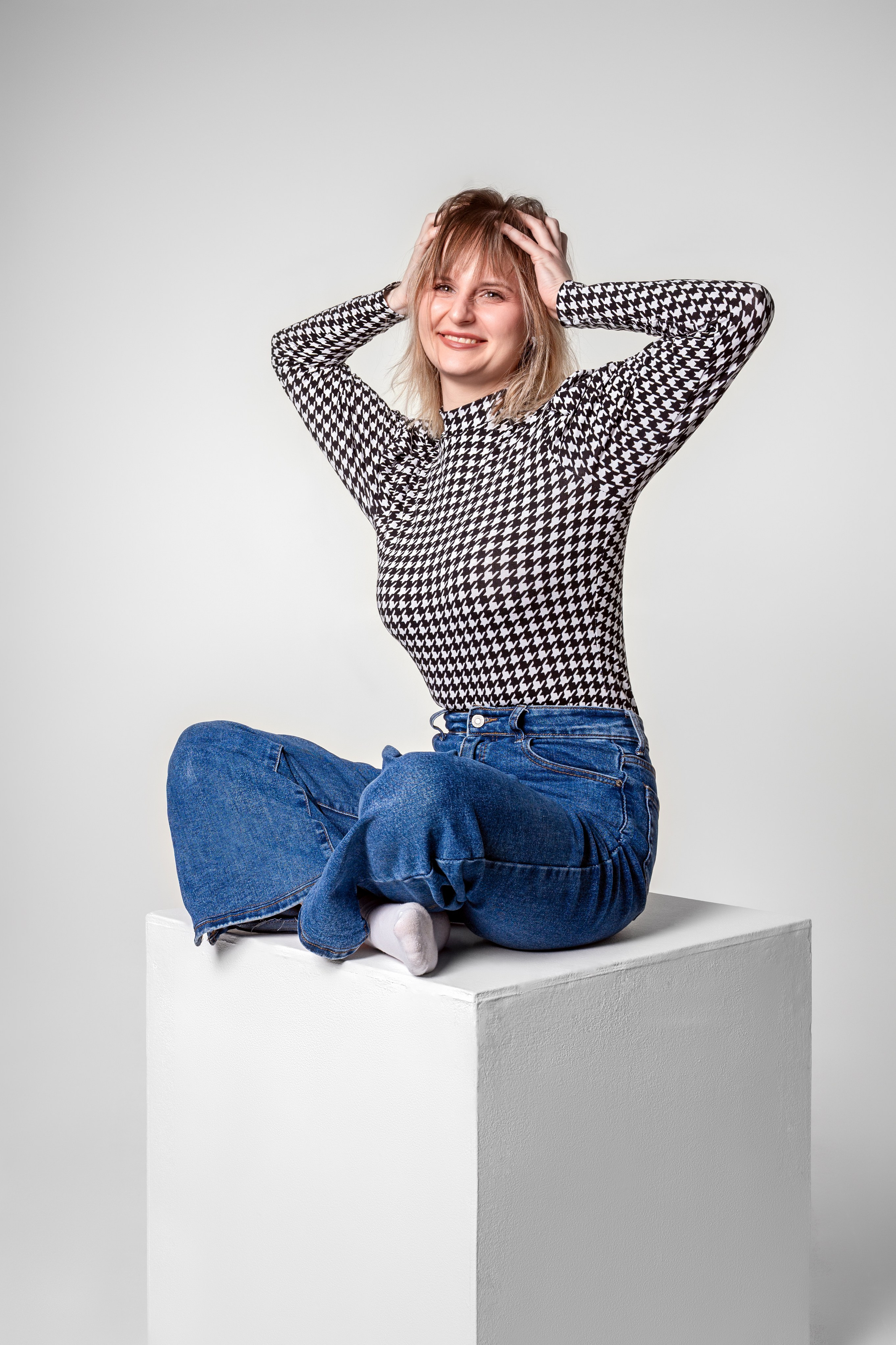 Фотосессия в студии во Владимире на циклораме, девушка позирует на белом кубе. Фотограф Смирнов Олег.