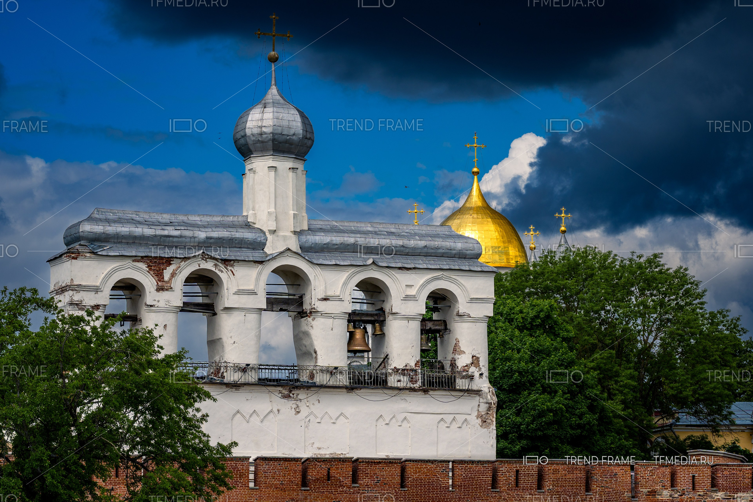 Софийская звонница и Золотой купол Софийского собора Великий Новгород фото TrendFrame, кремлёвская стена и крест на фоне облаков