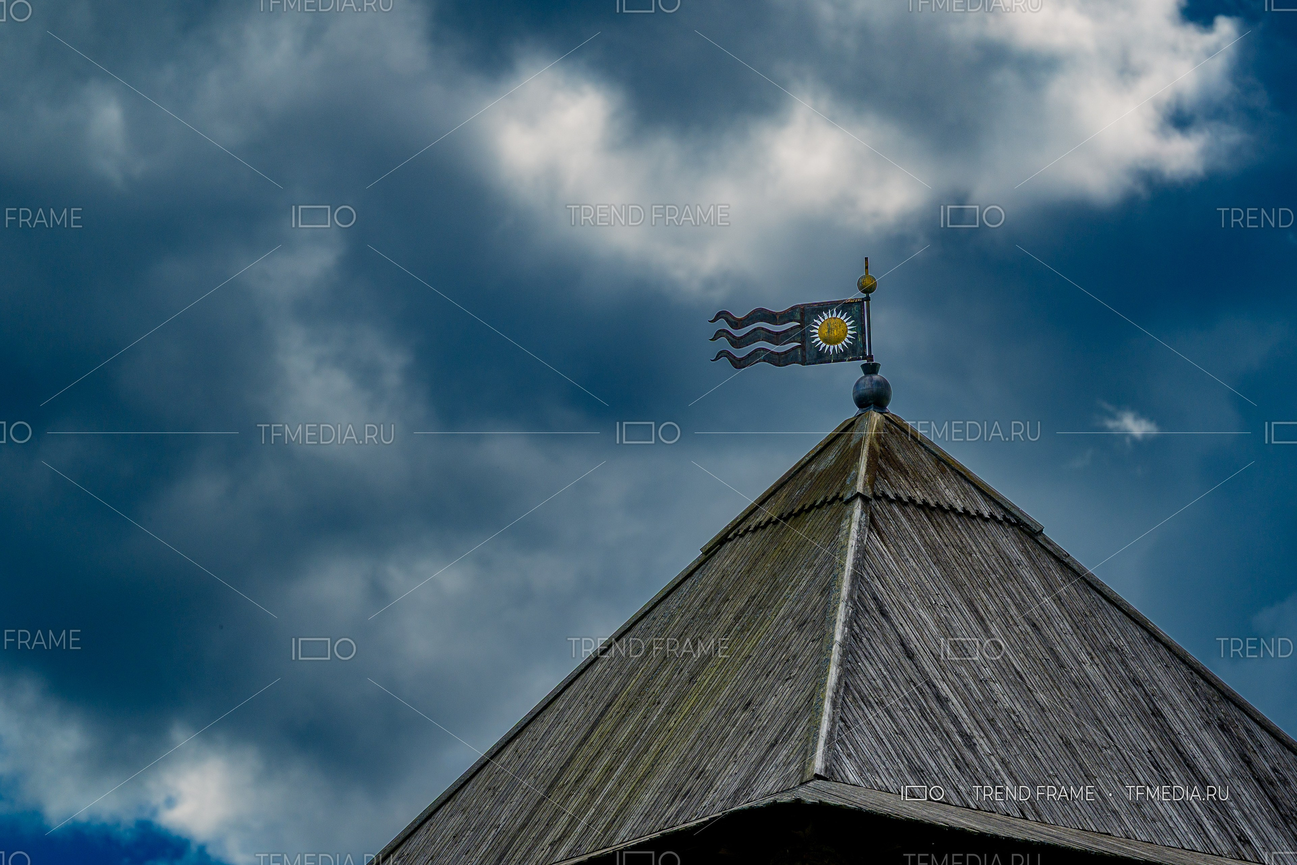 Шпиль Златоустовской башни кремля с флюгером на фоне драматического неба