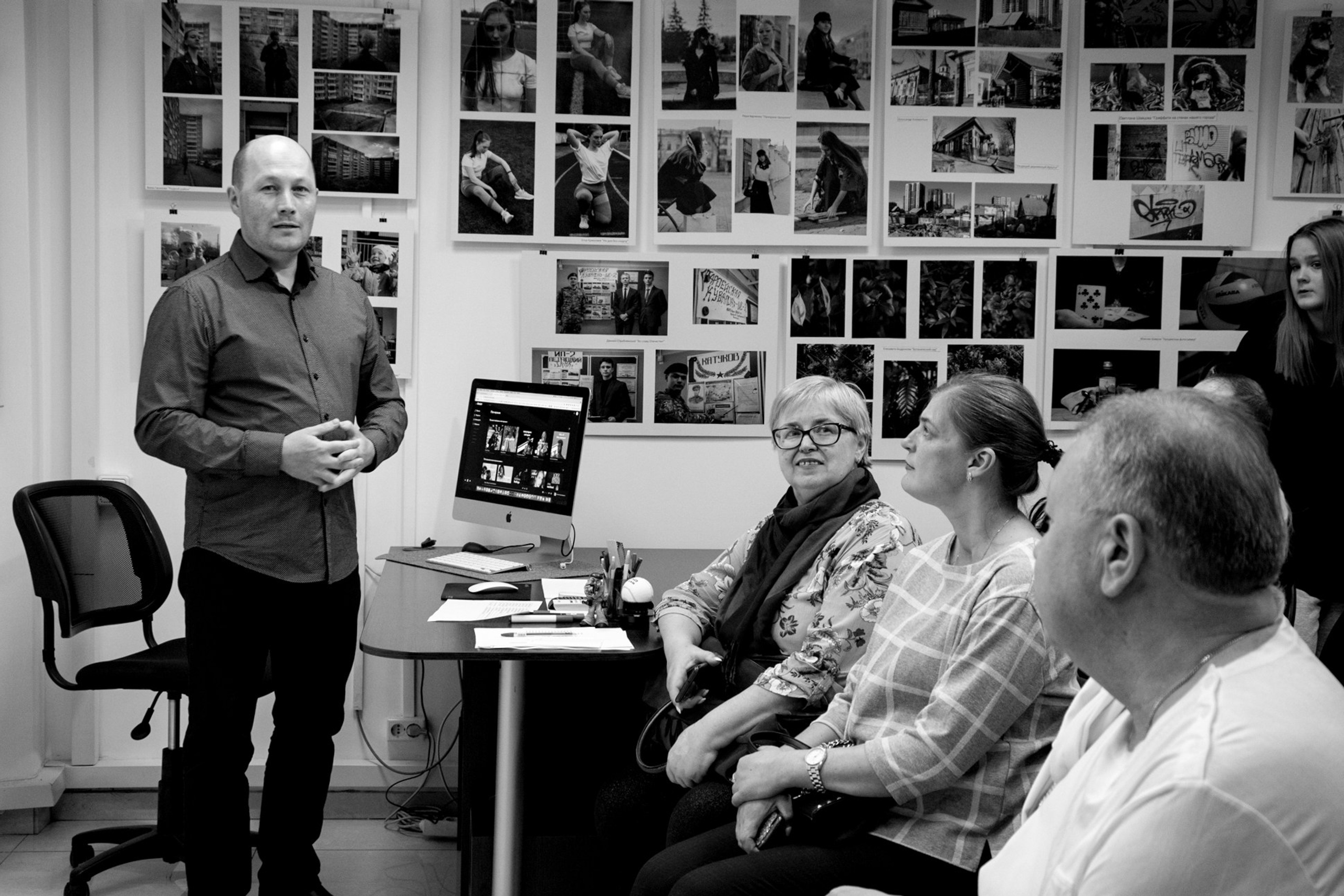 Преподаватель Артём Андронов организует и проводит для своих учеников фотовыставки. Это важный этап в становлении фотографа как творца. На стенах размещены работы учеников, собрались зрители. Артём делает открытие выставки.