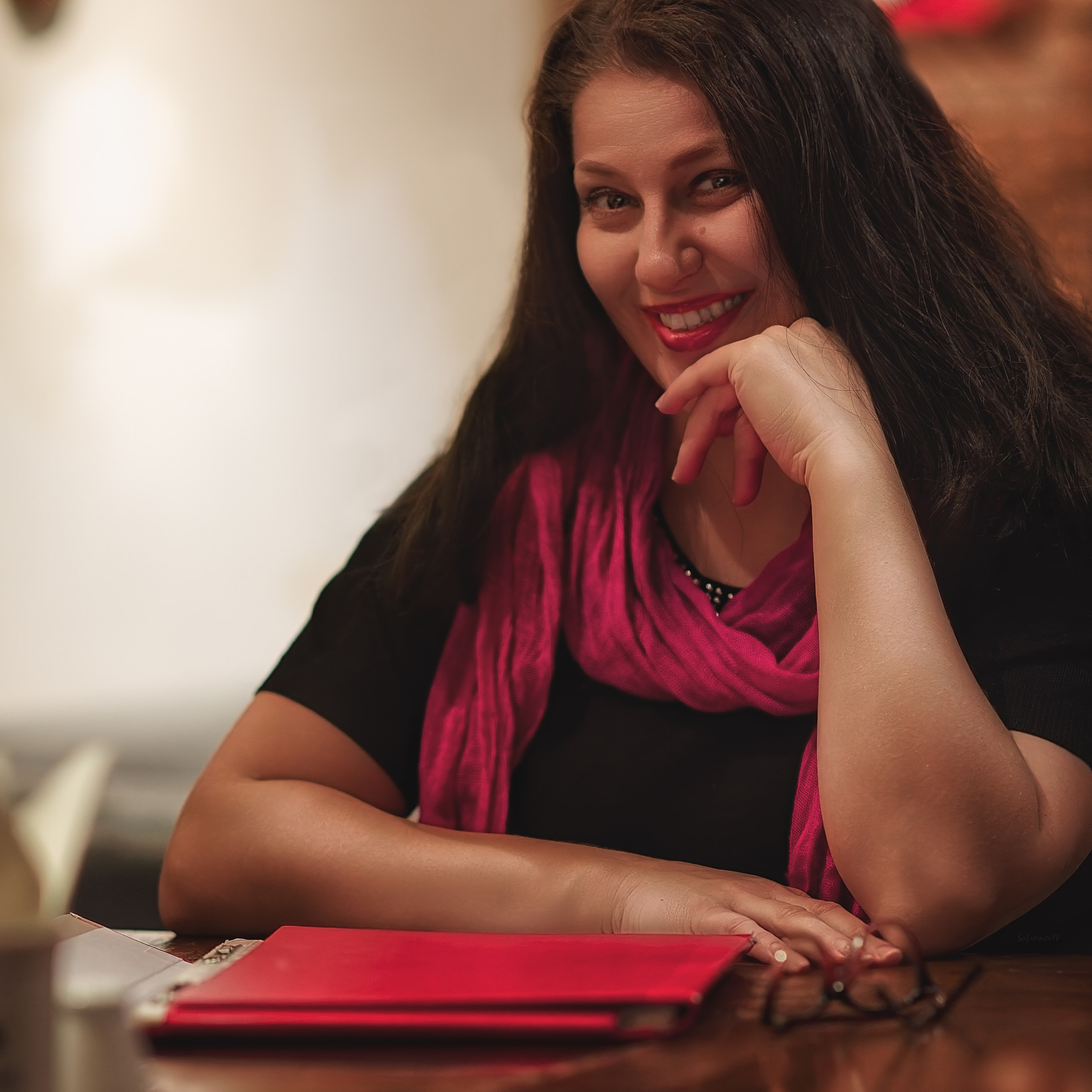 Красное меню лежит перед женщиной