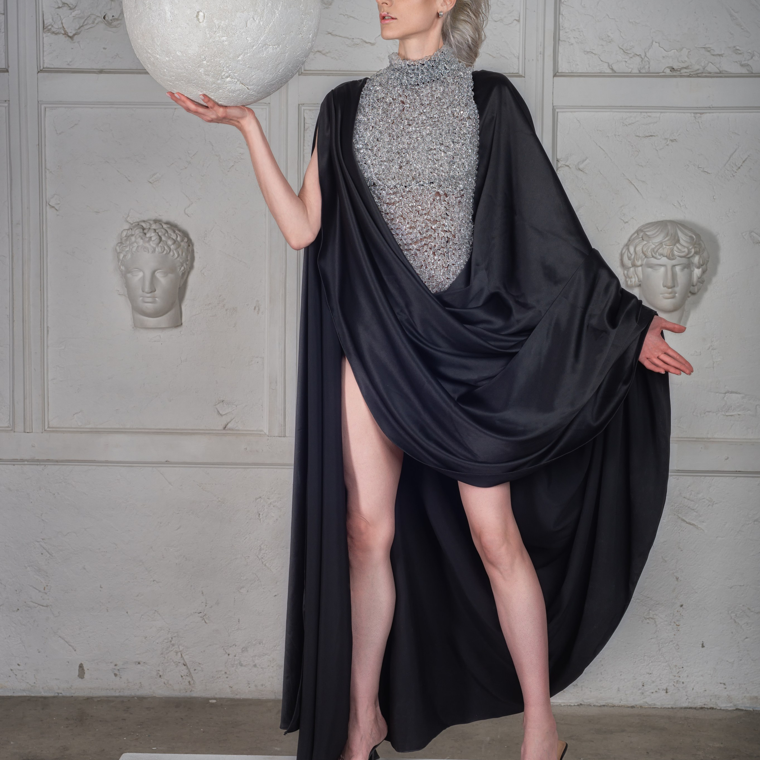 девушка в черной тоге держит сферу