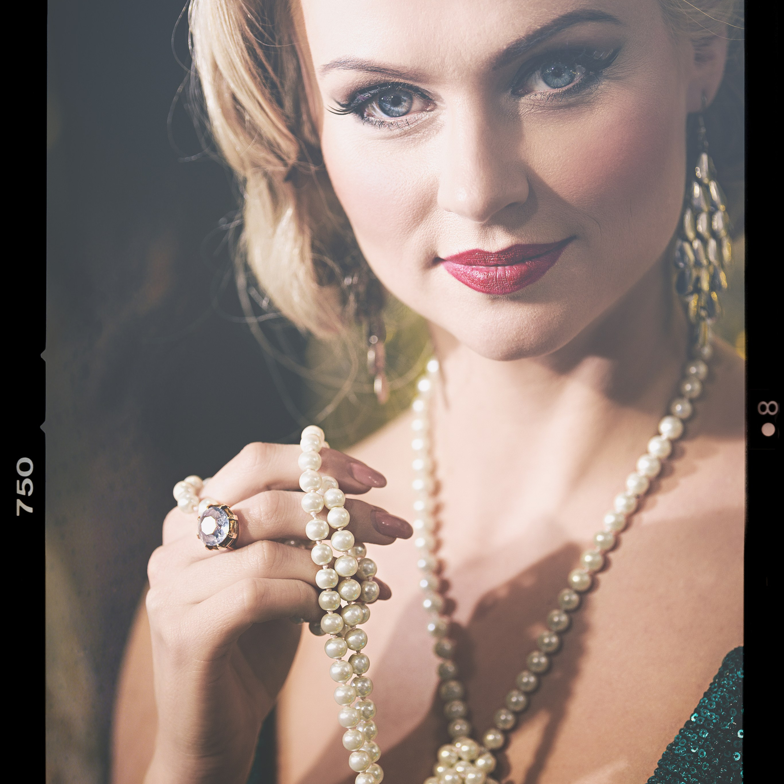 женщина с утонченным и элегантным образом. Она одета в блестящее платье, которое подчеркивает её изысканность. На шее и в руках у неё жемчужные украшения, которые добавляют образу классической роскоши. Её взгляд наполнен уверенностью и загадочностью, а макияж и прическа подчеркивают её красоту. Свет падает на лицо, создавая эффектный контраст и акцентируя внимание на её чертах.Заголовок: «Жемчужная элегантность»Ключевые слова: портрет, жемчужные украшения, классическая элегантность, фотограф Сафронов Иван, Москва.