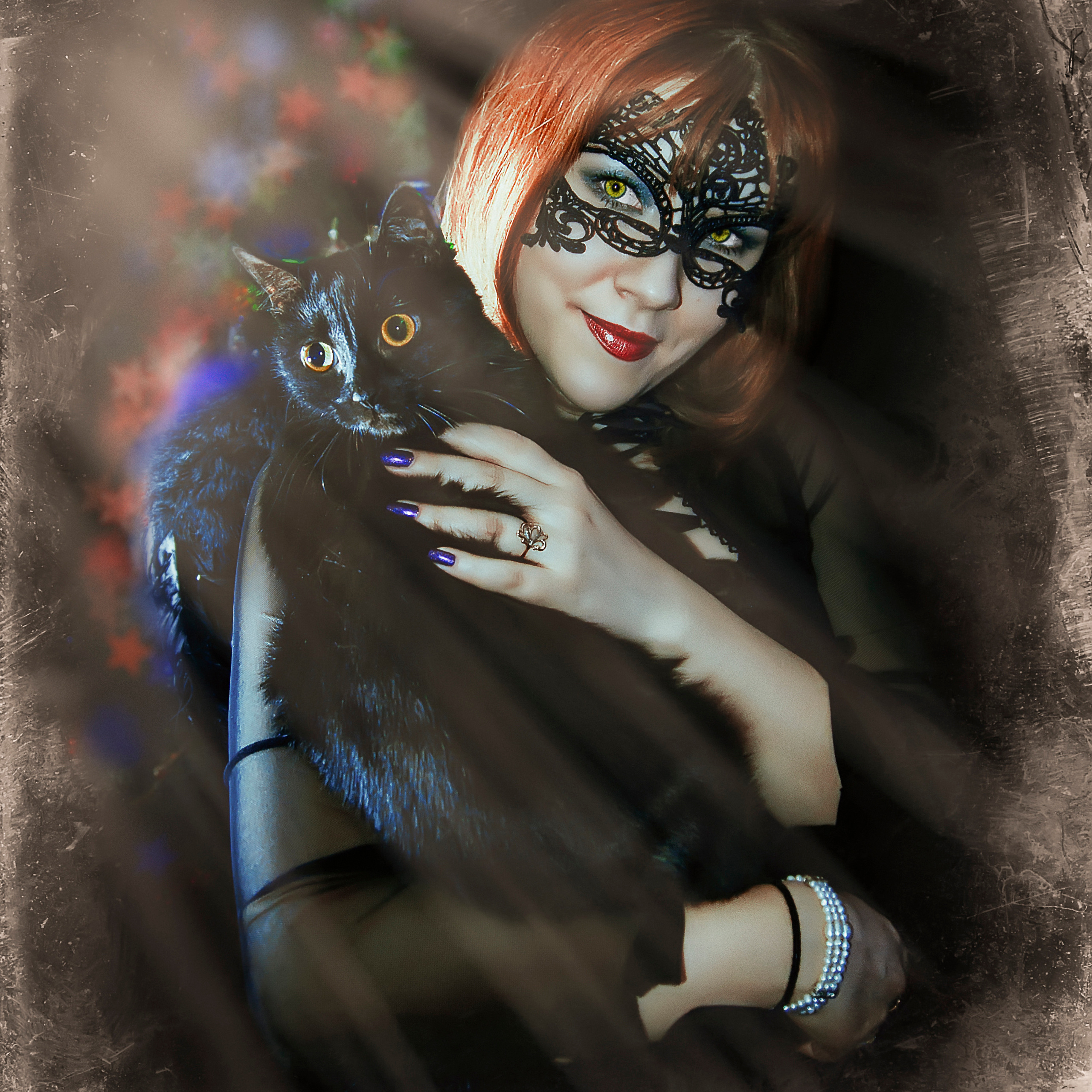 Девушка в черной маске с черной кошкой на руках