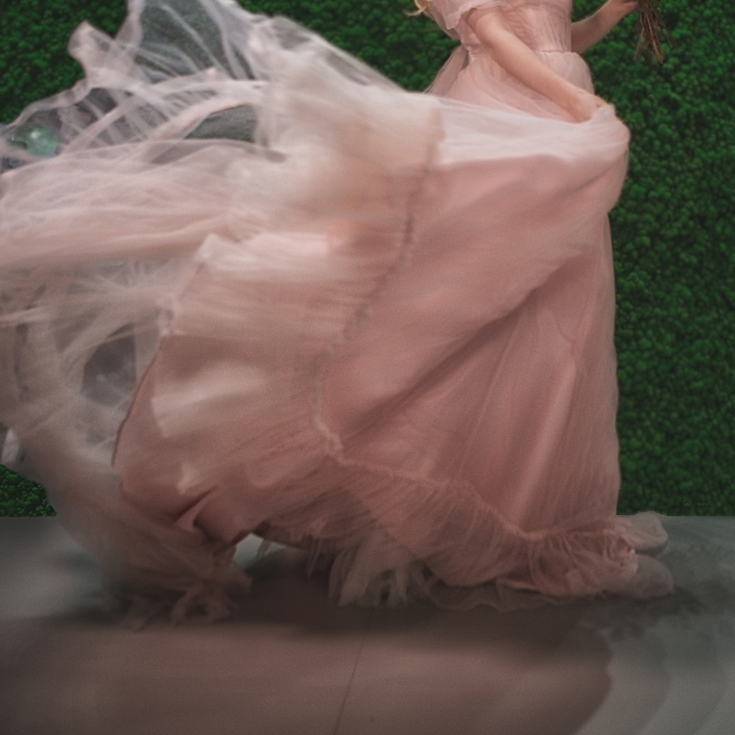 Девушка с букетом цветов размахивает розовым платьем