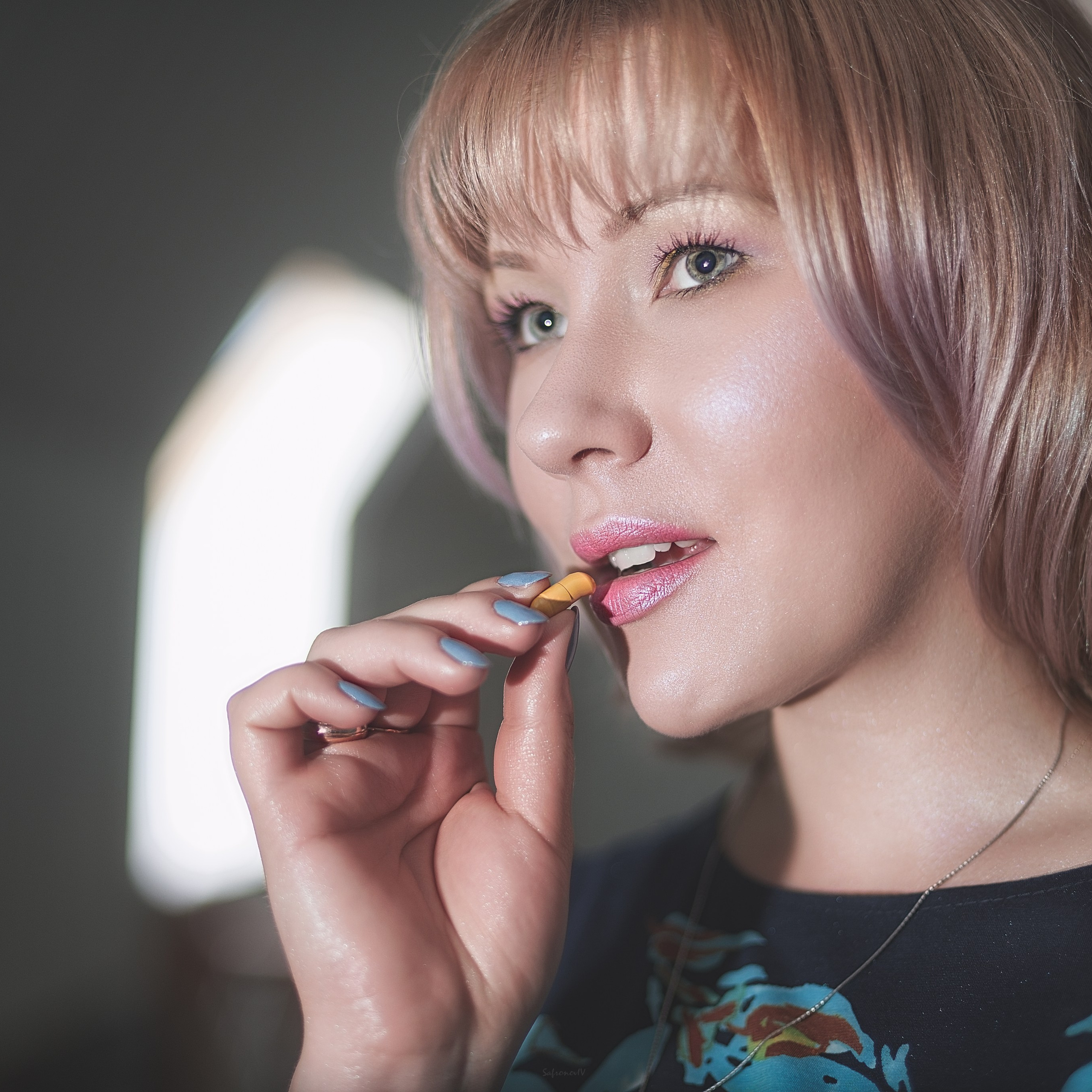 Девушка кладет таблетку в рот