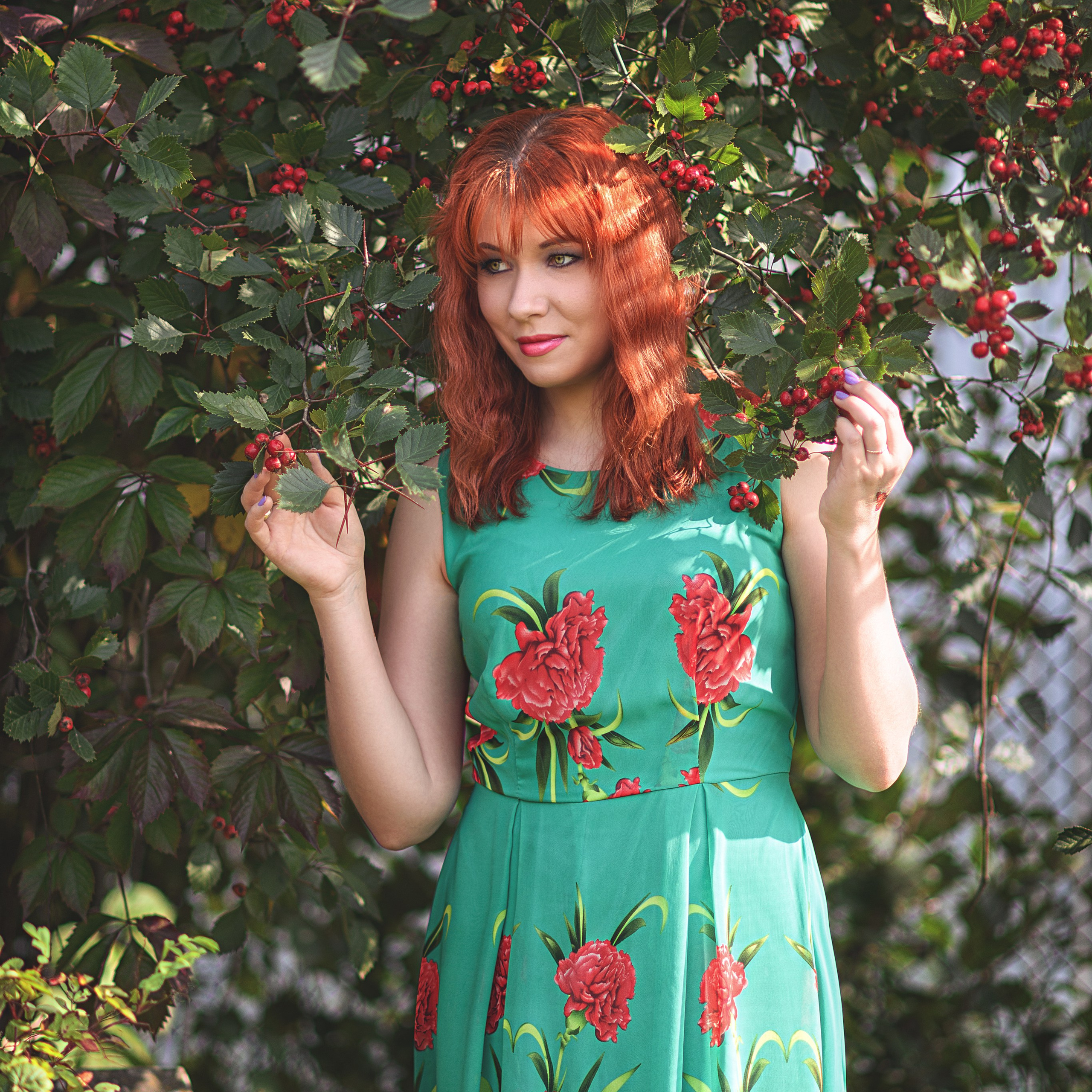 Девушка в зеленом платье прячется в рябине