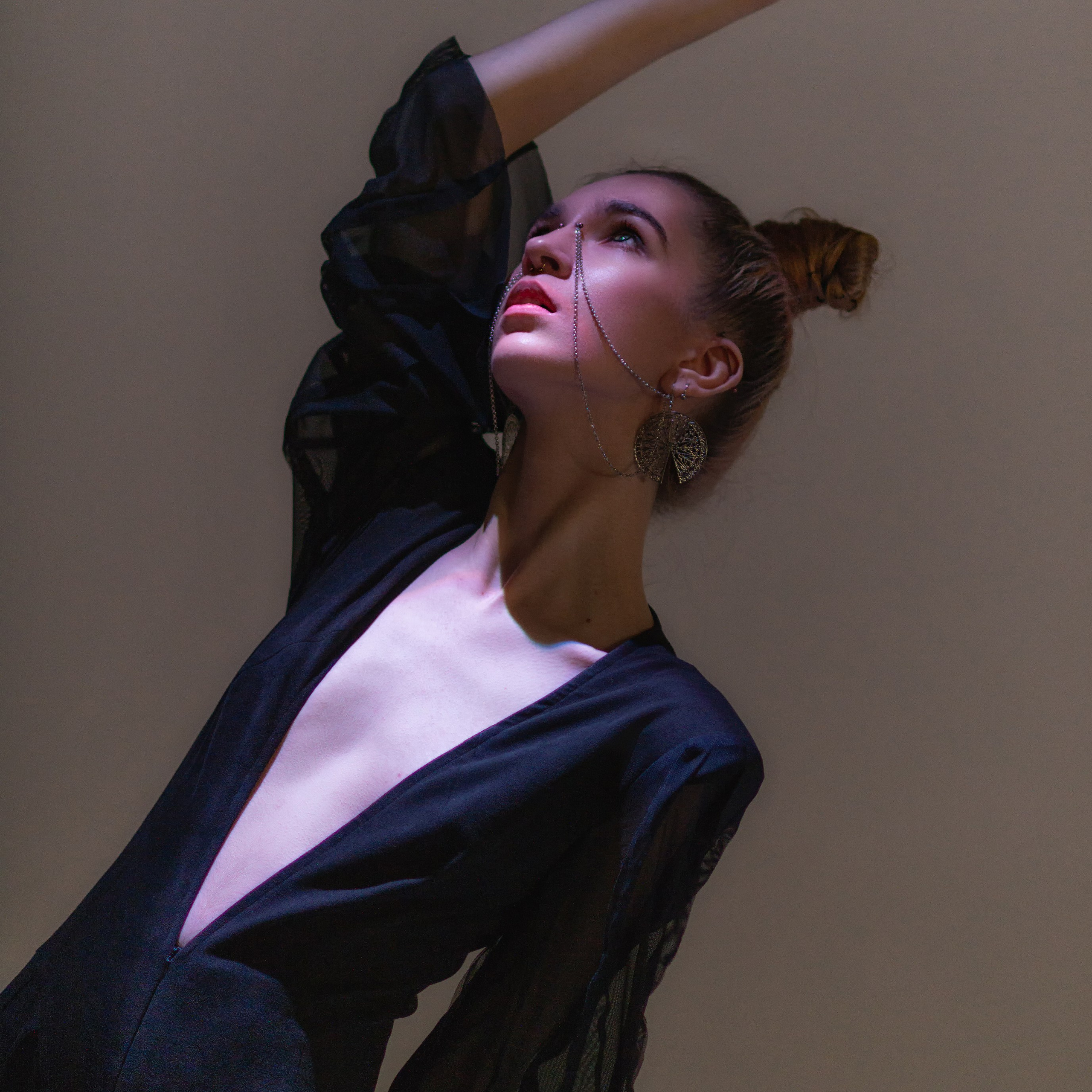 Девушка в уникальной одежде поднимает руку вверх и прячется от света