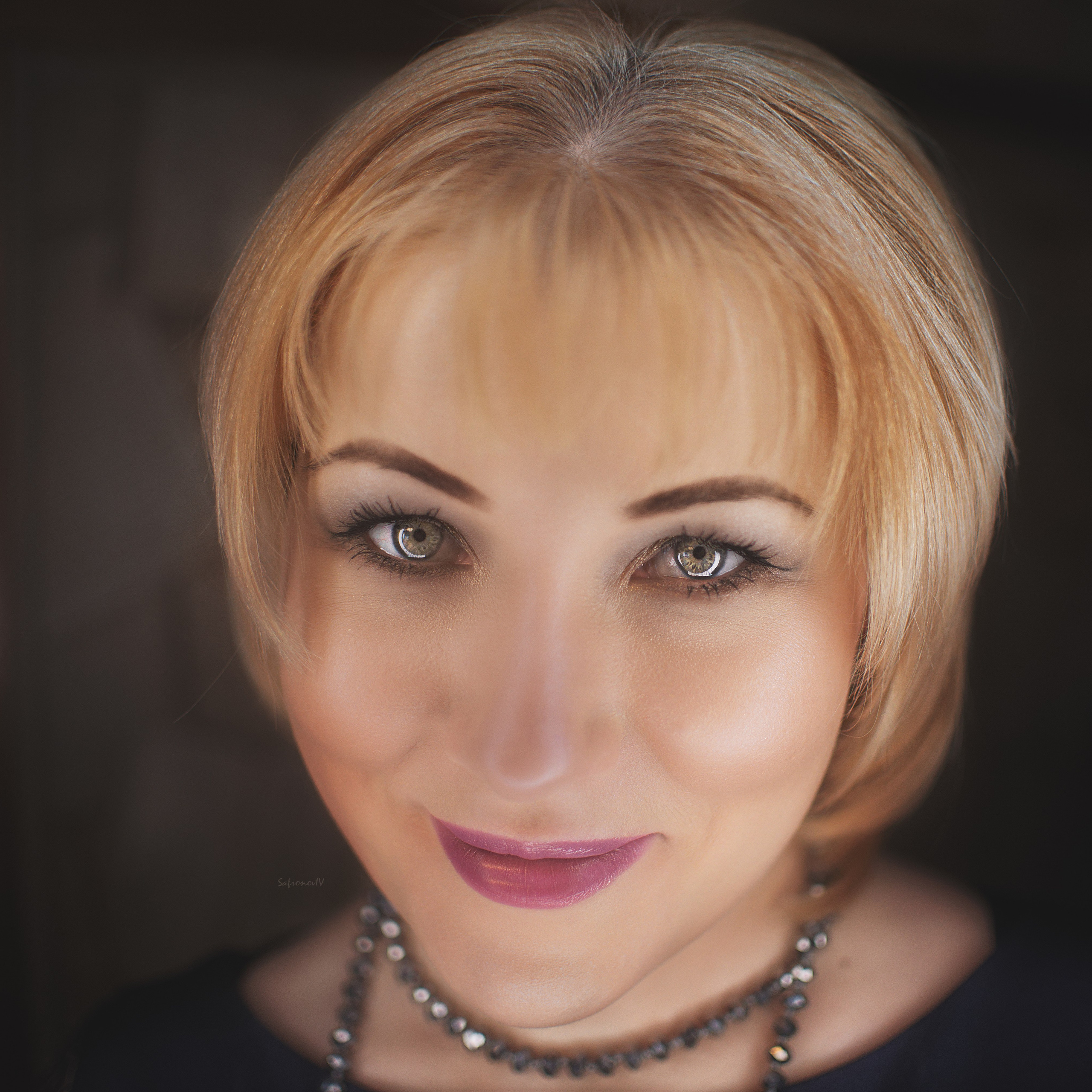 Блондинка с яркими глазами в черных бусах